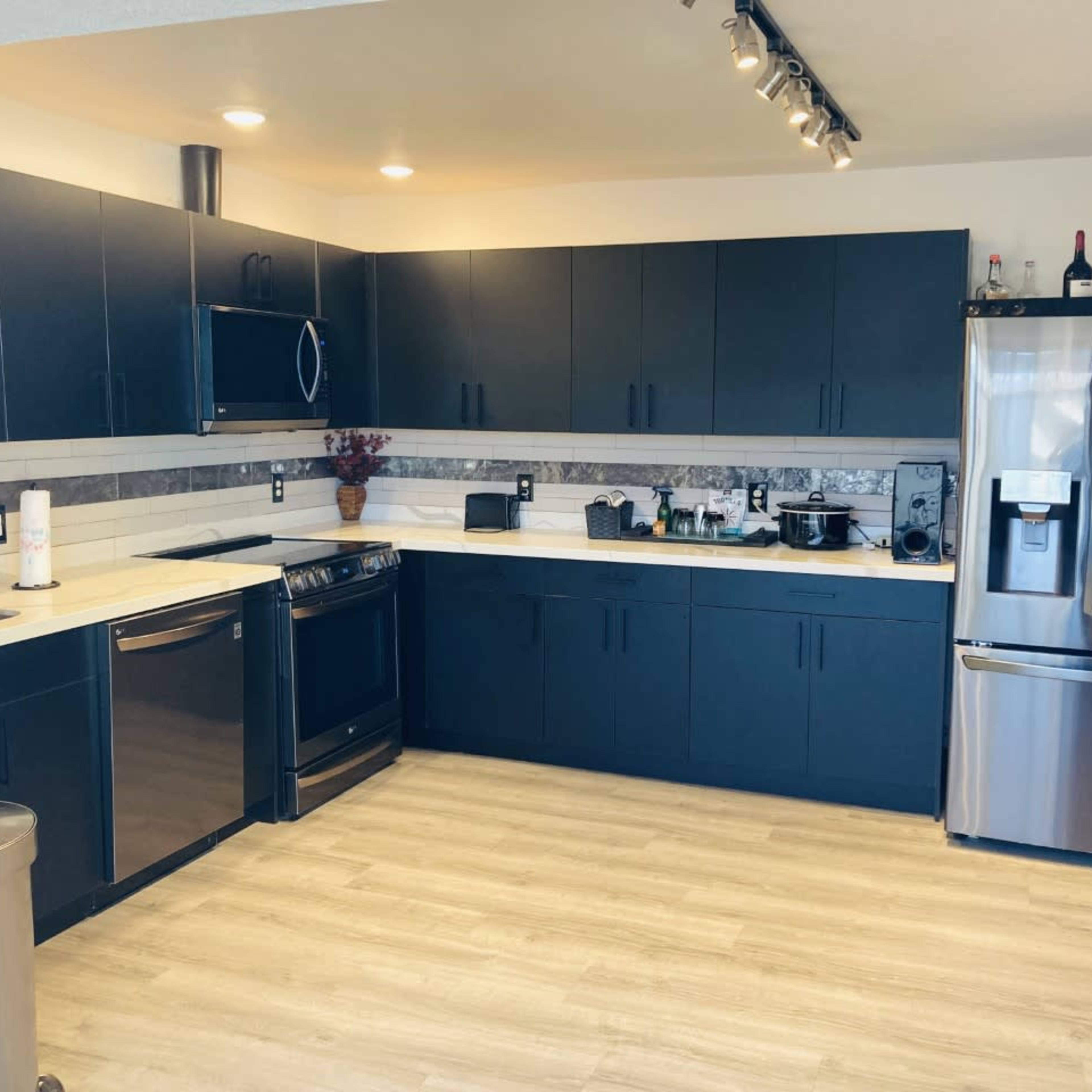 The kitchen features black cabinetry, stainless steel appliances, and a light-colored countertop.