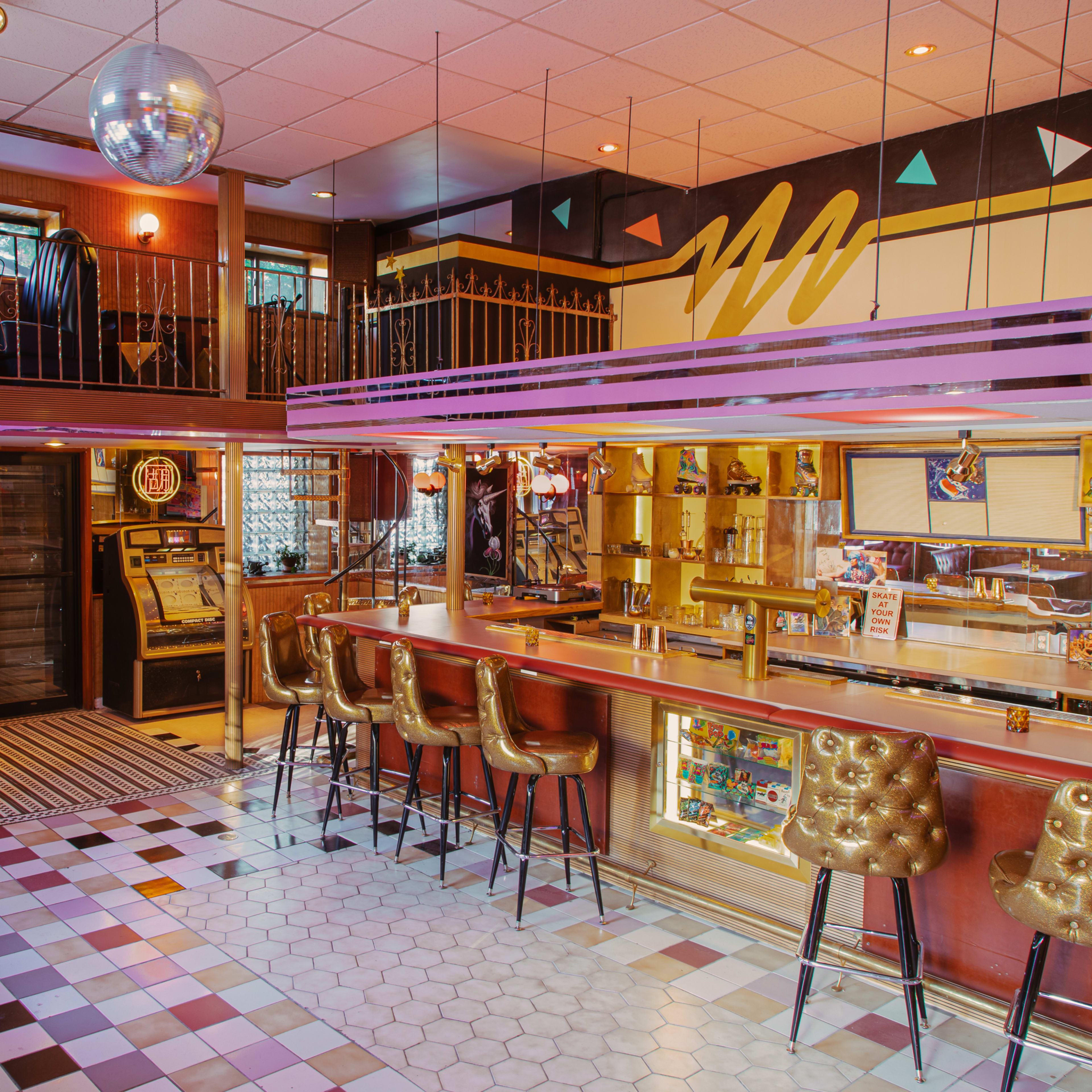 A retro-style bar with a disco ball, colorful decor, and a seating area featuring patterned flooring.