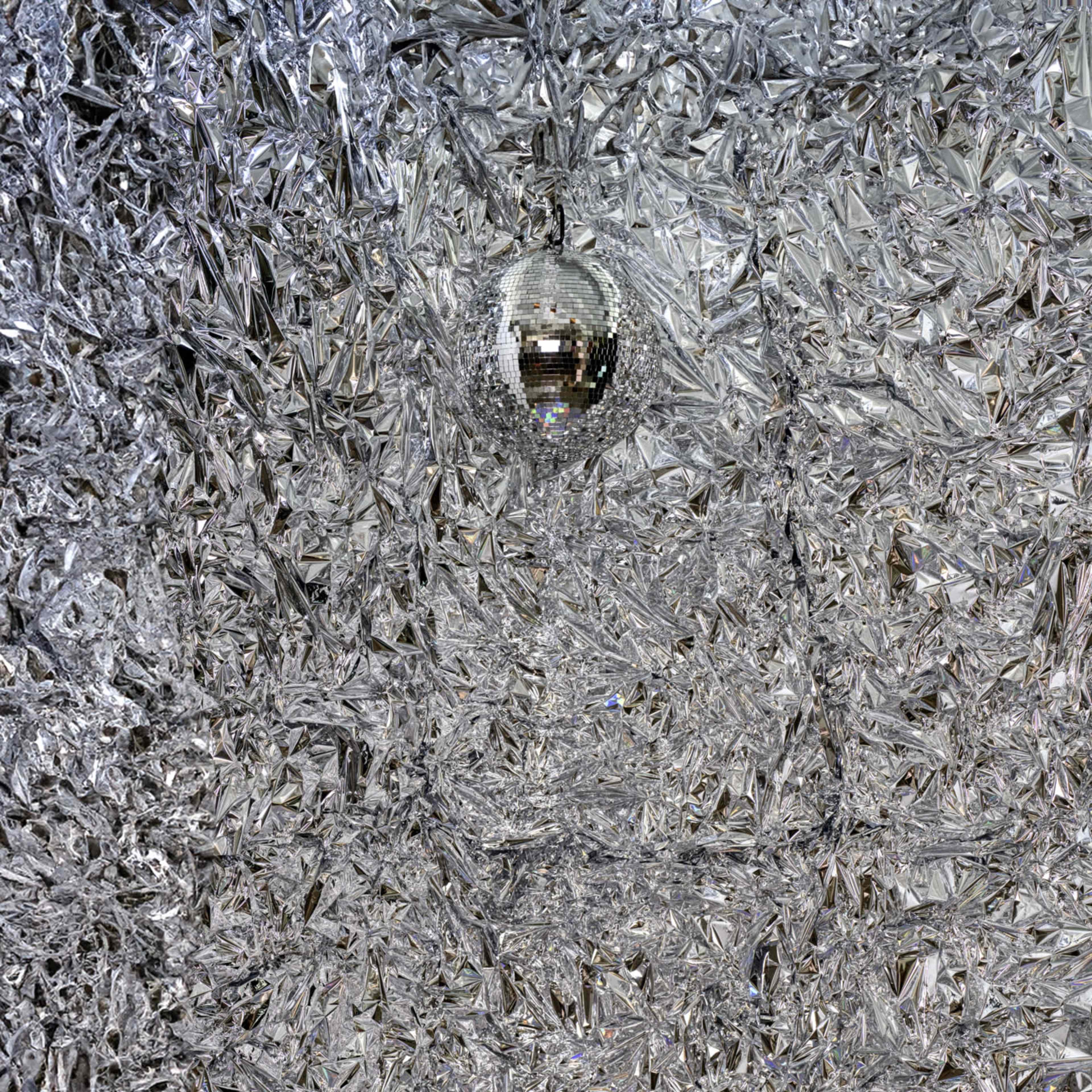 A room covered in reflective, silver, crystal-like surfaces with a disco ball hanging from the ceiling.