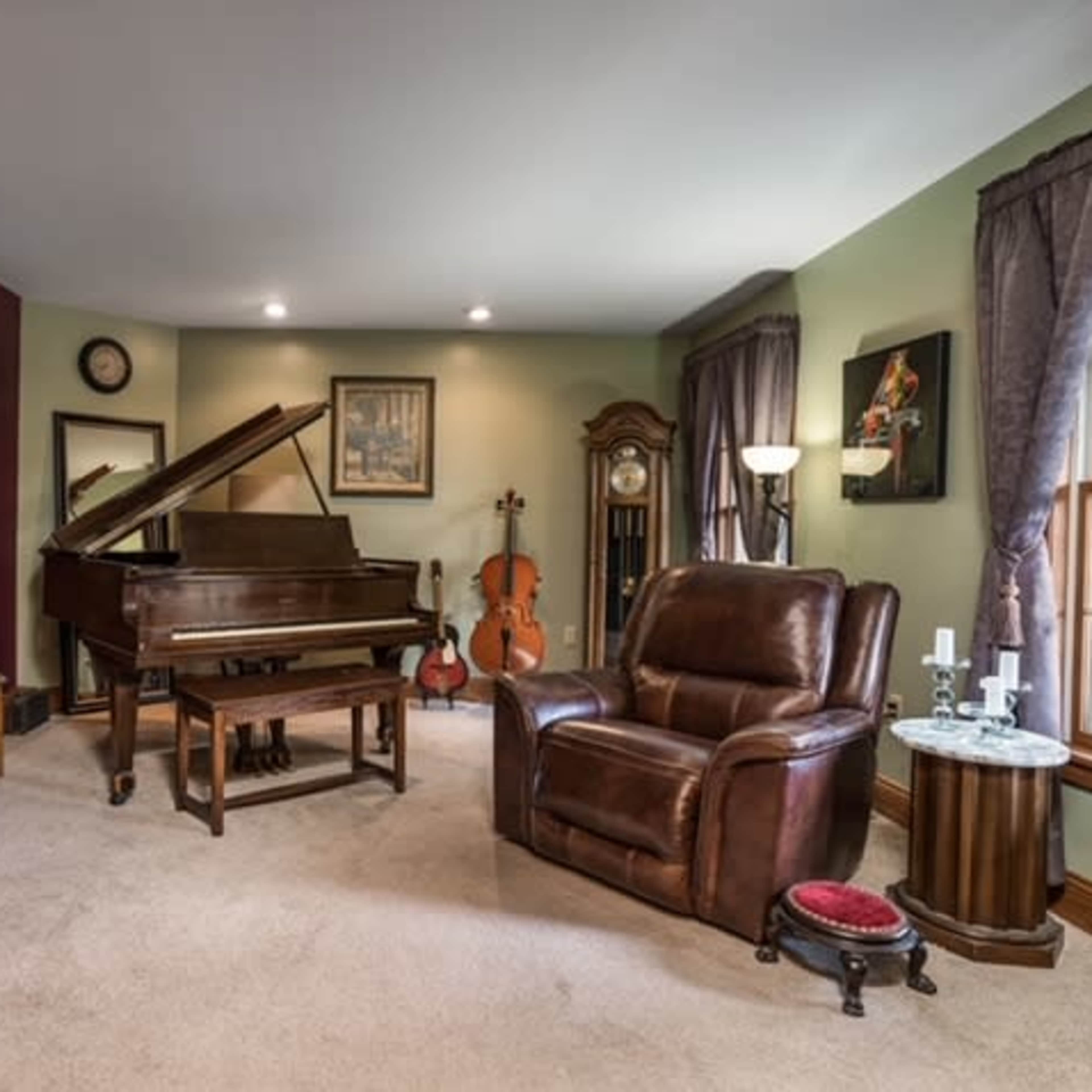 A living room with a grand piano, a classic clock, a violin, and a brown leather armchair, surrounded by art pieces and soft lighting.