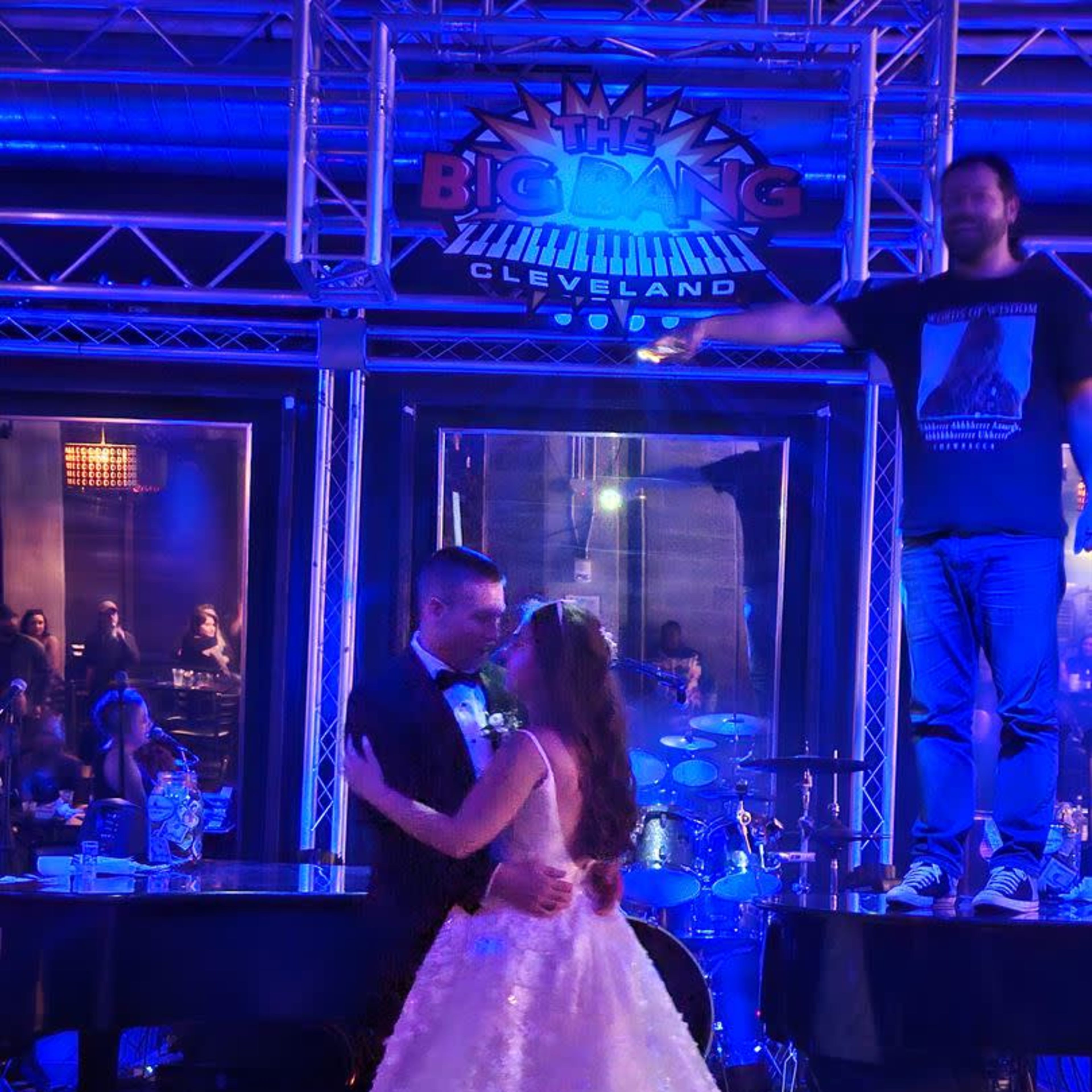 A bride and groom dance together on a stage in front of a live band at a venue called The Big Bang in Cleveland.