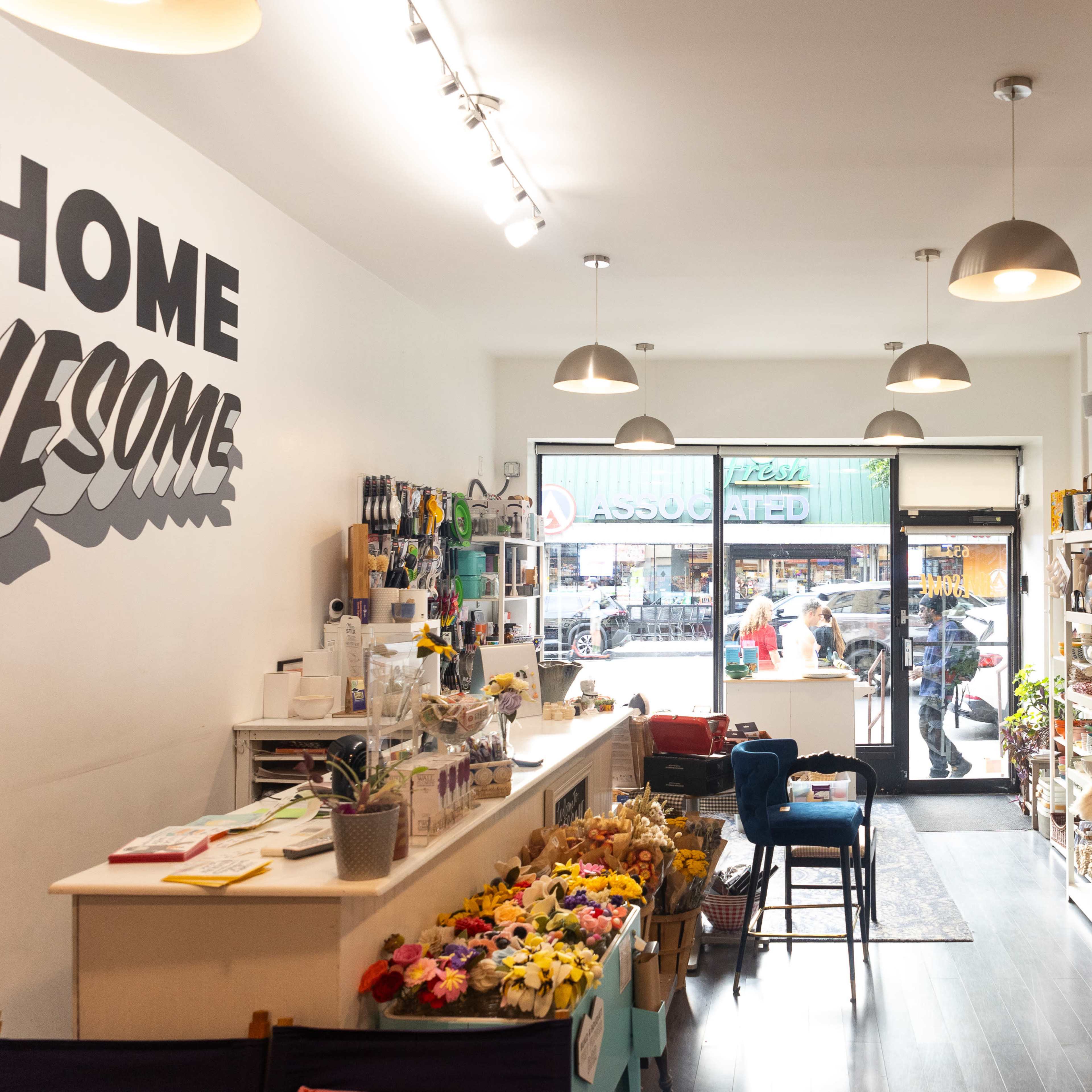 The interior of a retail store with shelves displaying various products and a view of the street through the front entrance.