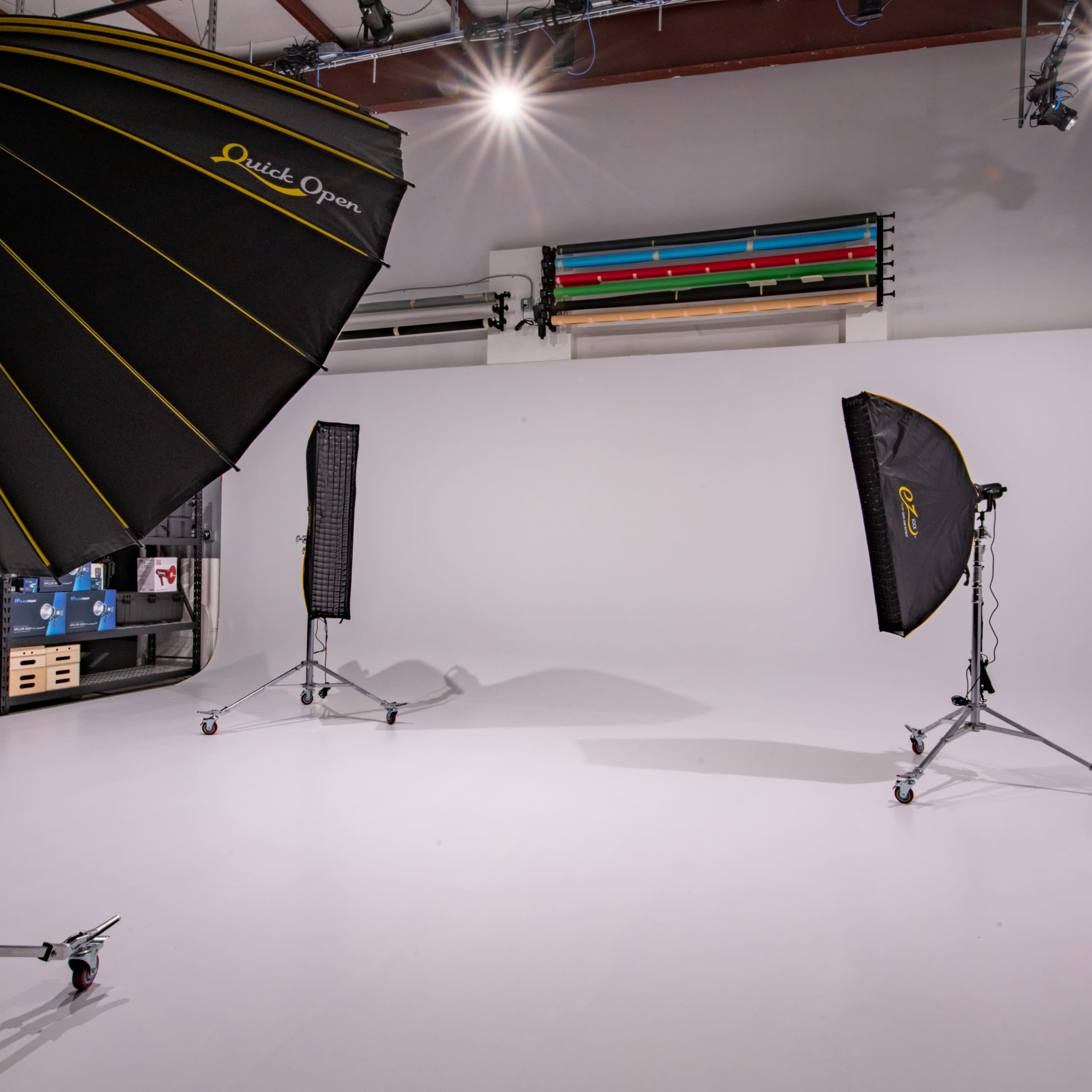 A photography studio setup with several large softbox lights and a seamless white backdrop.
