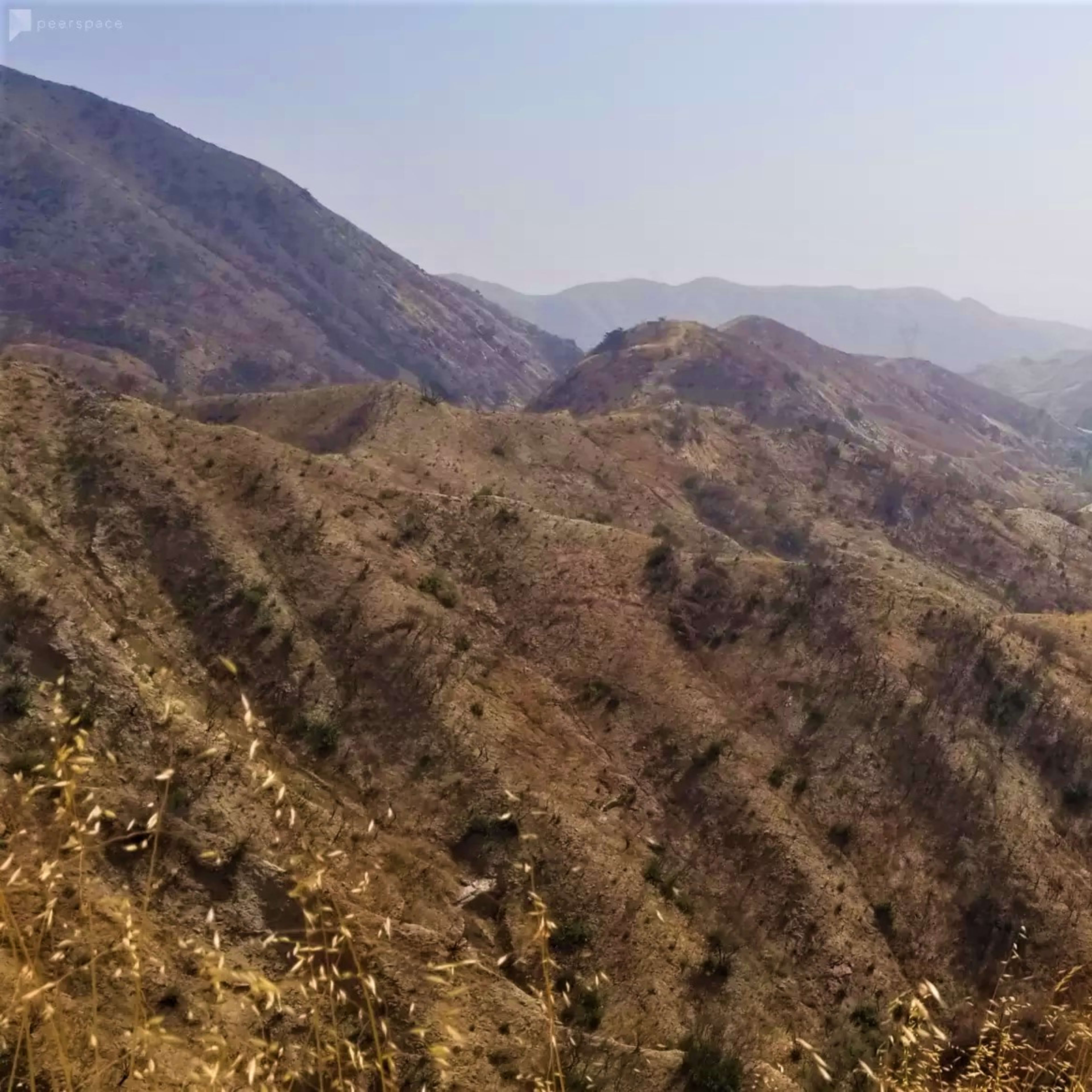 A winding river flows through a dry mountainous landscape with sparse vegetation and steep hillsides.