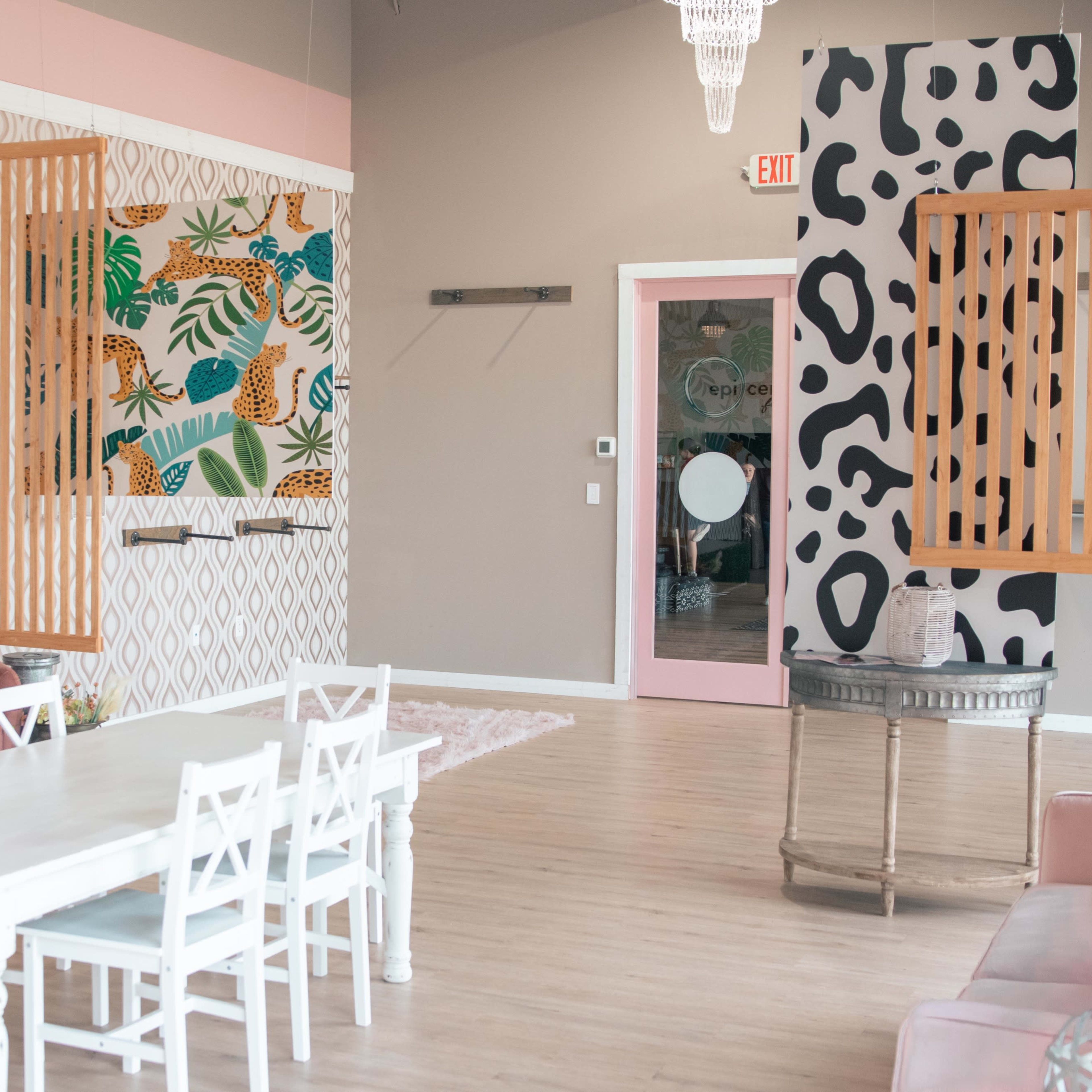 A brightly decorated room featuring a white dining table with chairs, colorful wall murals, and a mix of contemporary design elements.