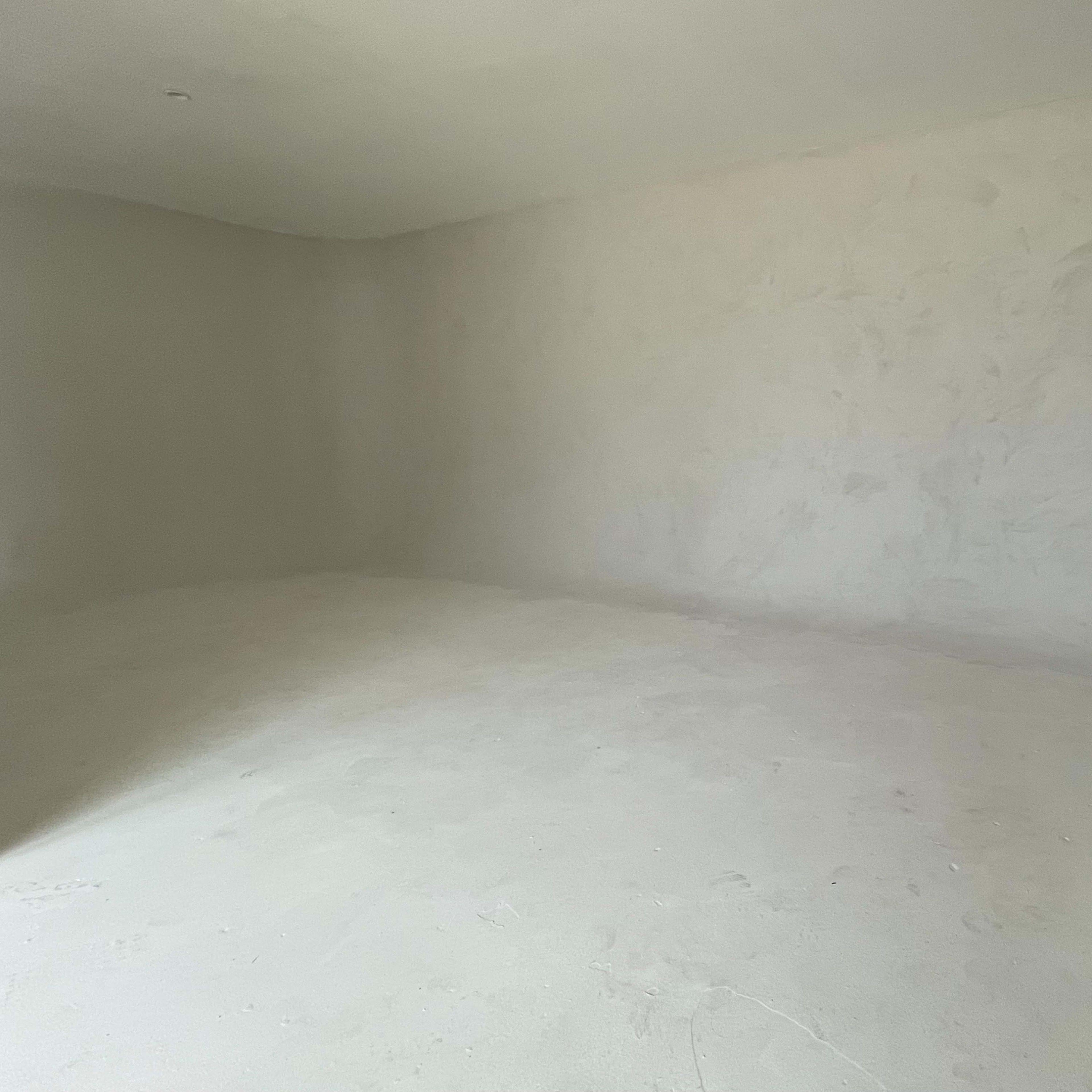 An empty room with unadorned walls and a bare floor.