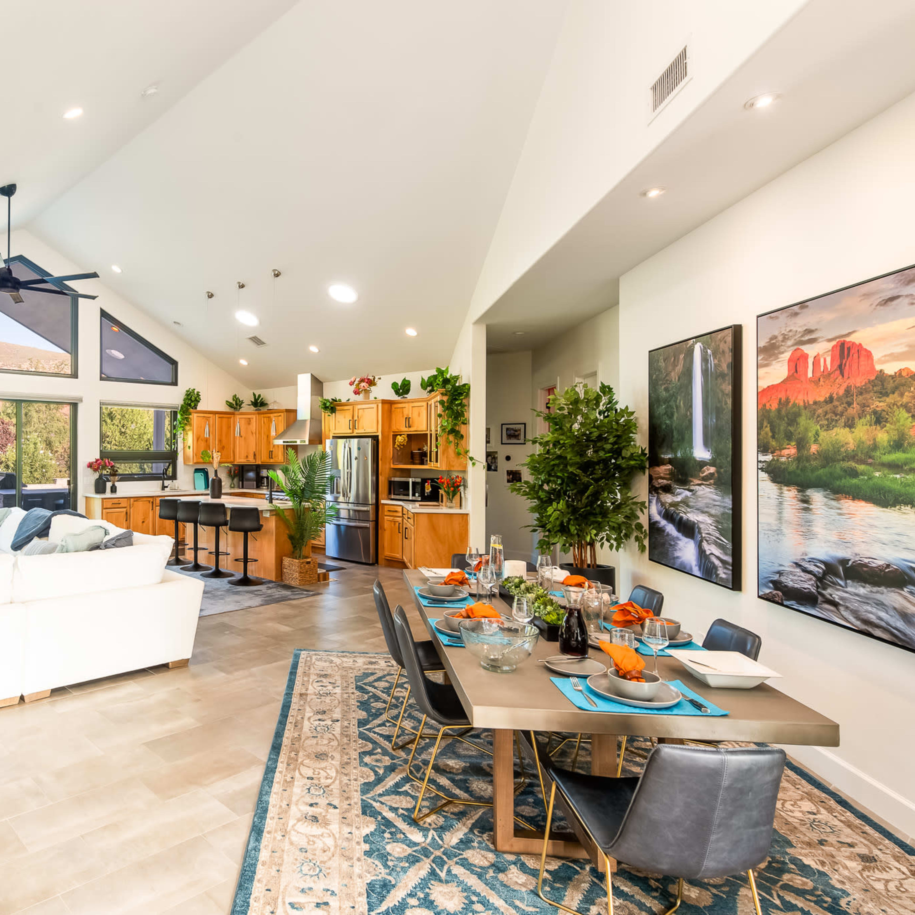 The open-concept living and dining area features a modern kitchen, a spacious seating arrangement, and large windows that overlook a landscaped outdoor space.