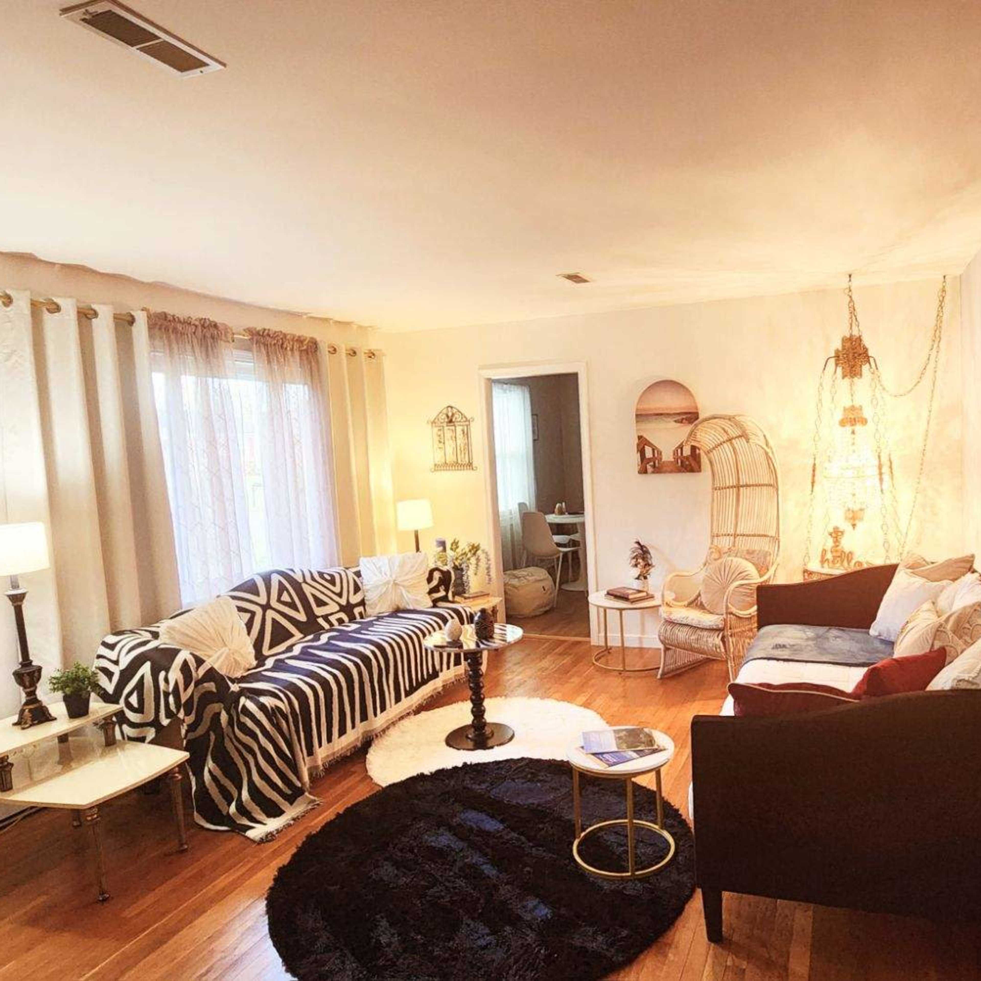 The living room features a mix of patterned furniture, a round rug, and soft lighting.