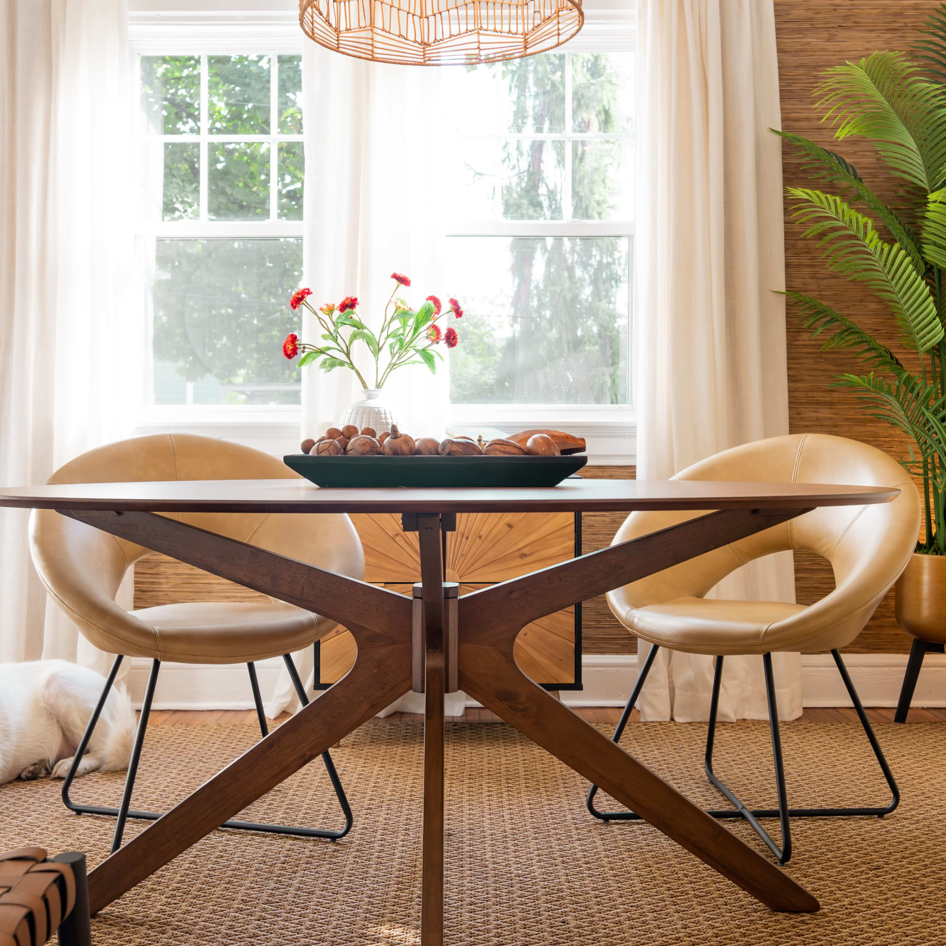 A Labrador dog lies on the floor beside a round wooden dining table surrounded by modern chairs in a well-lit room.