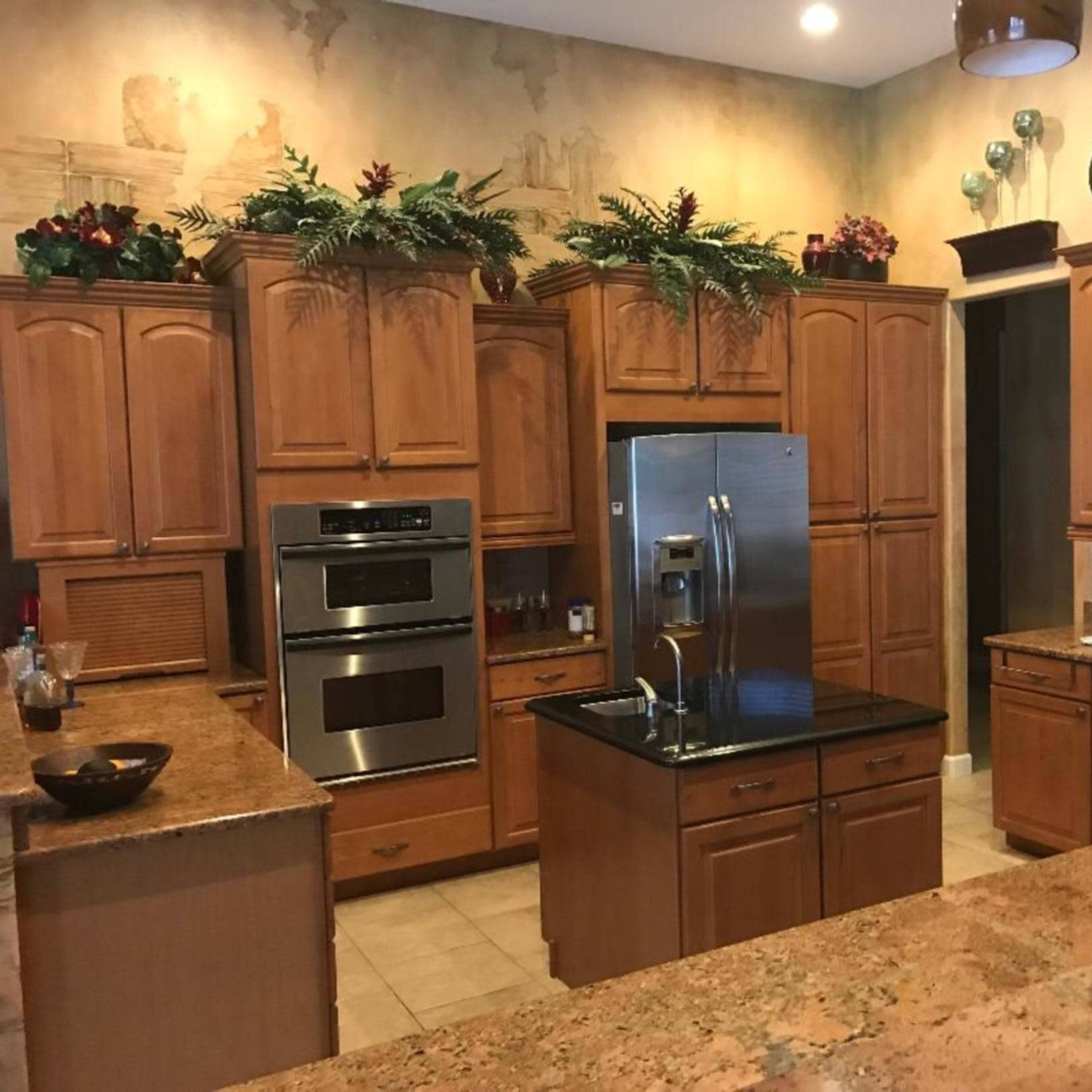 The kitchen features wooden cabinetry, modern appliances, and a central island with a dark countertop.