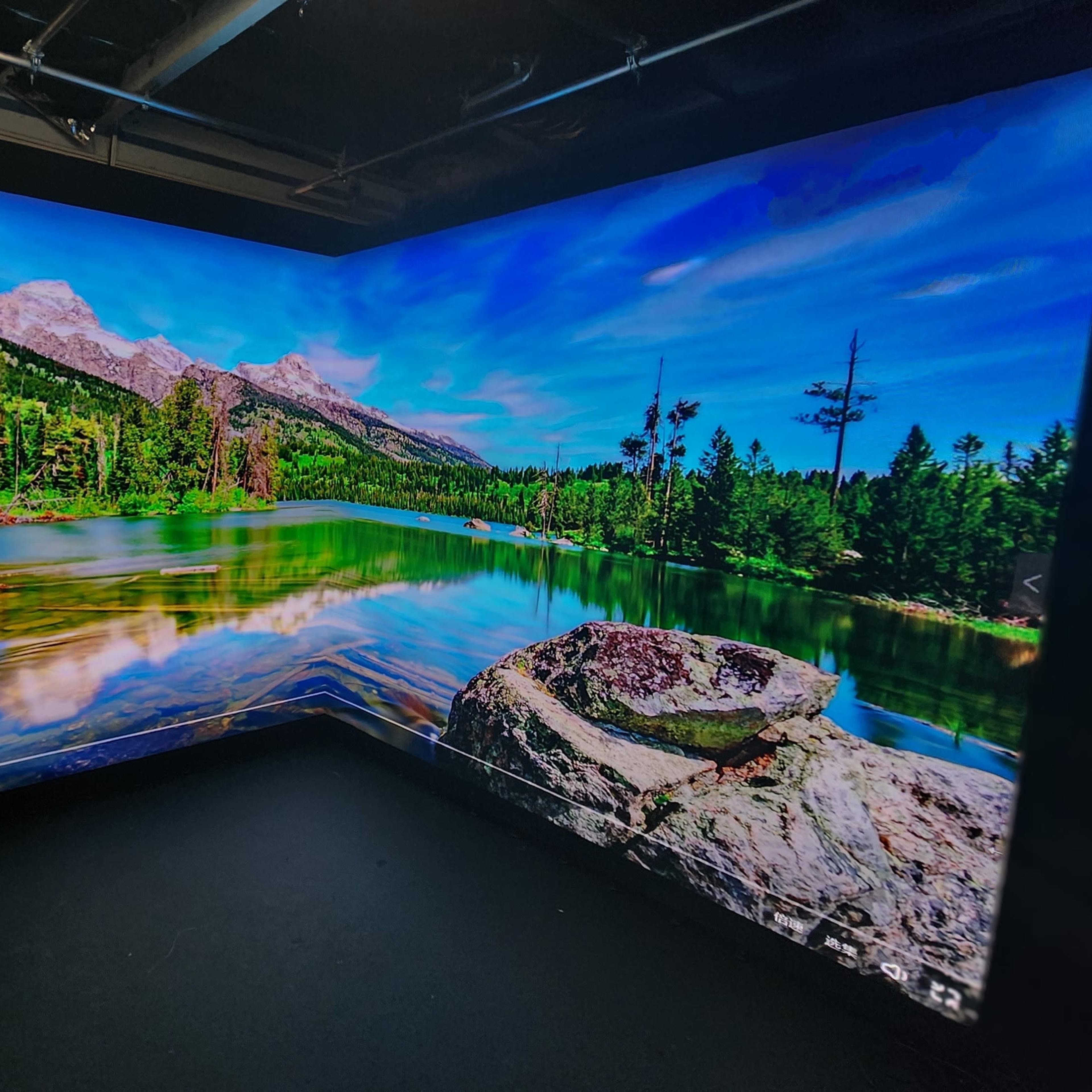 A large display featuring a scenic view of a mountain lake surrounded by trees and rocky terrain.