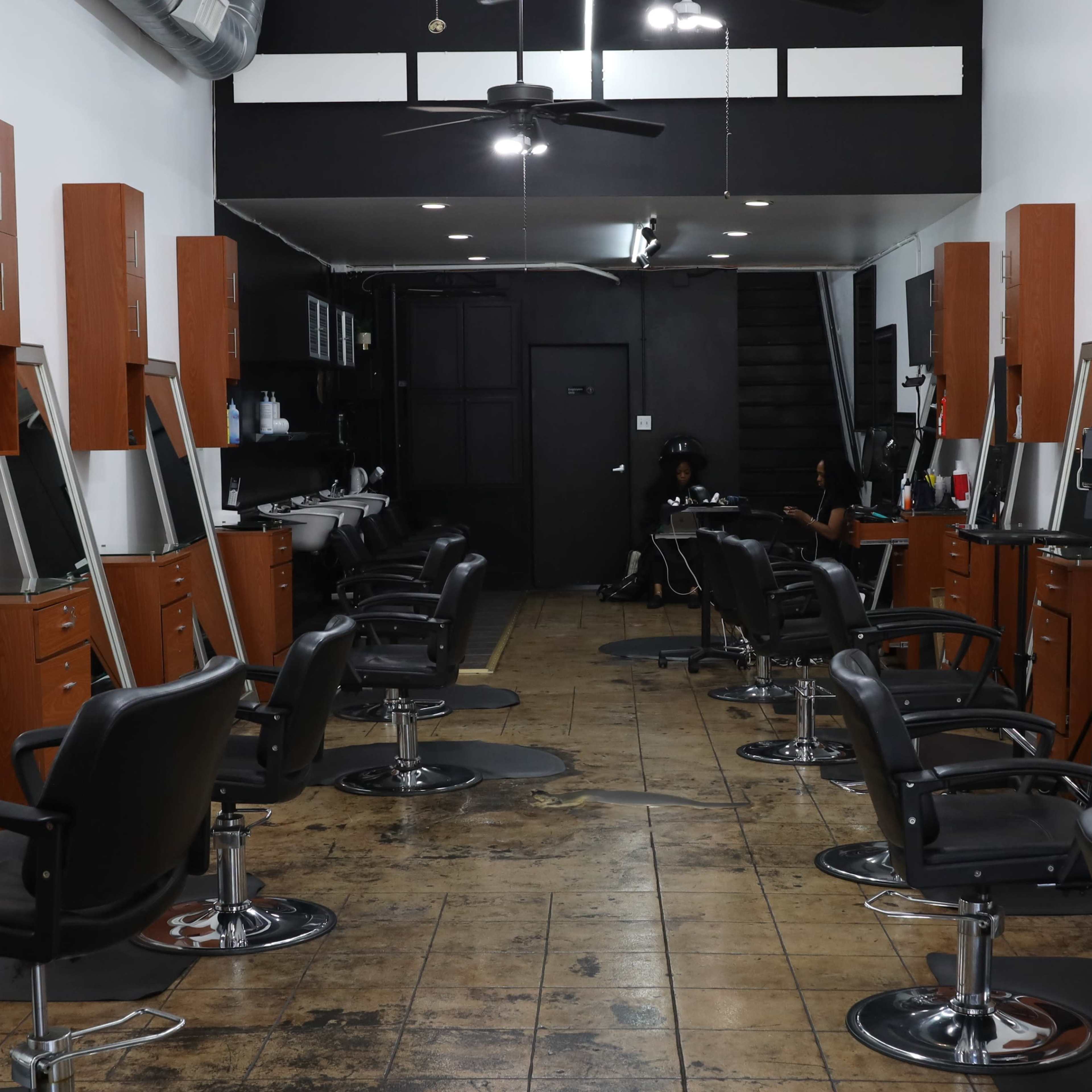 A row of salon chairs with mirrors in a modern hair salon.