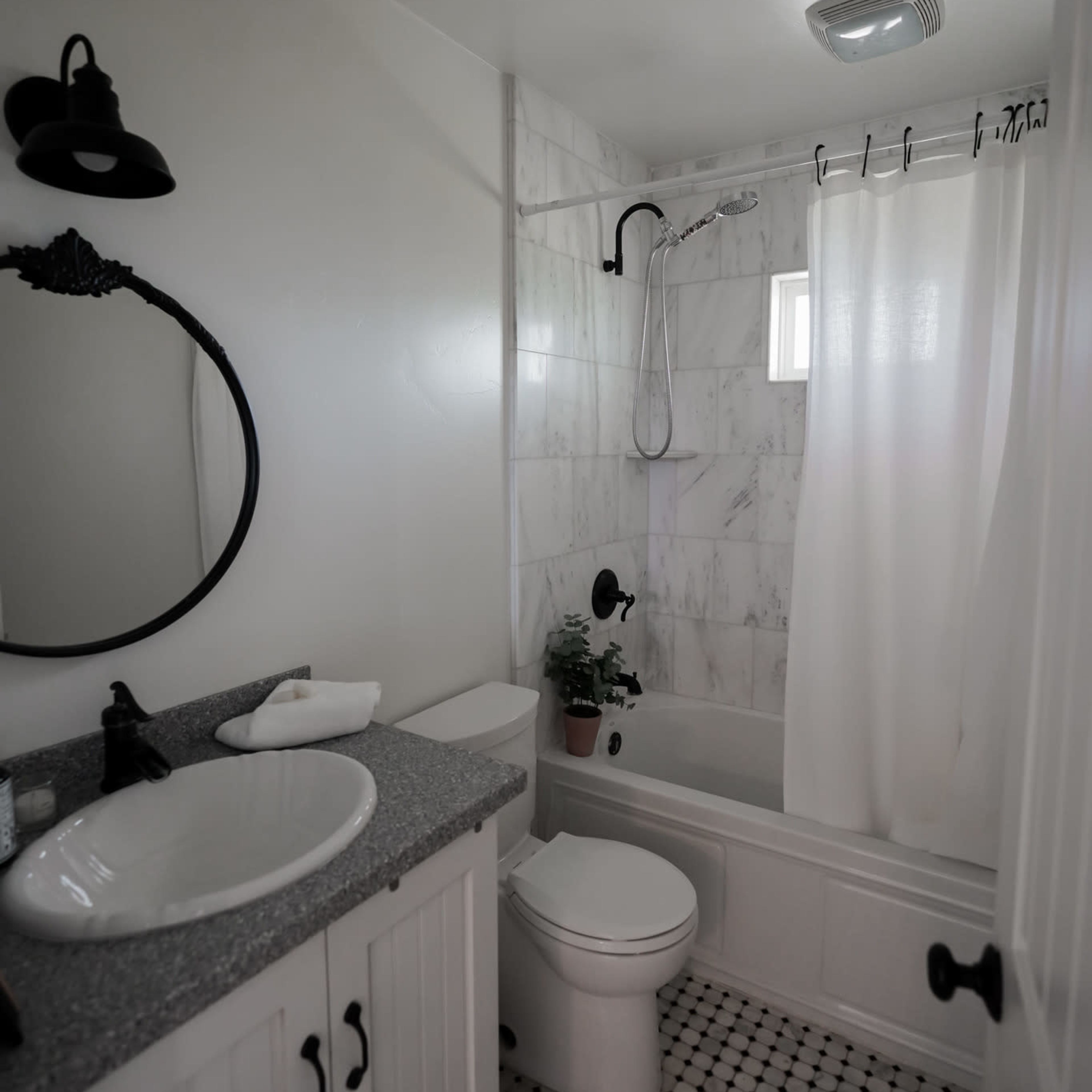 A clean bathroom features a bathtub with a shower, a round mirror, and dark fixtures against a white tiled wall.