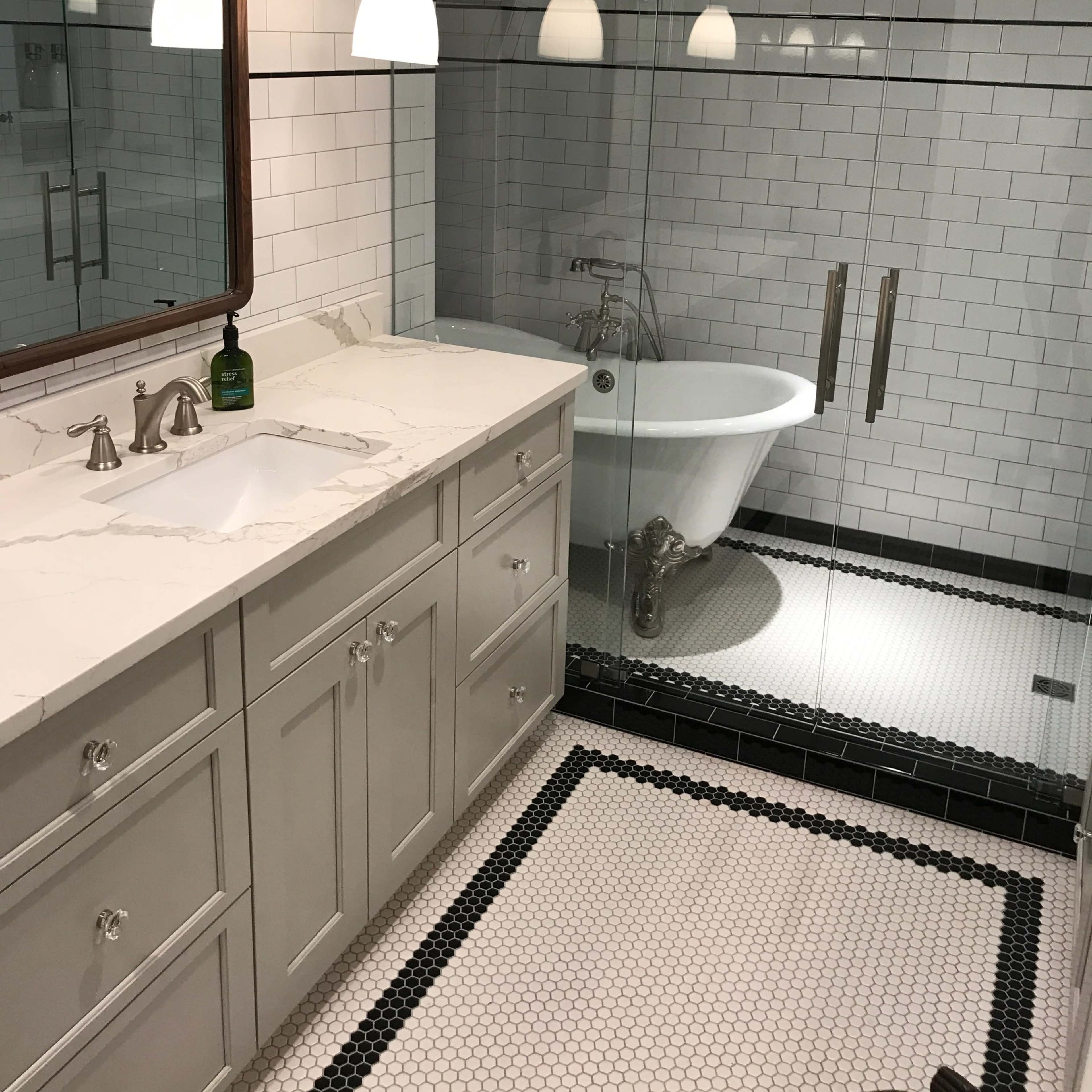 A modern bathroom featuring a freestanding bathtub, a glass-enclosed shower, and a double-sink vanity with a marble countertop.