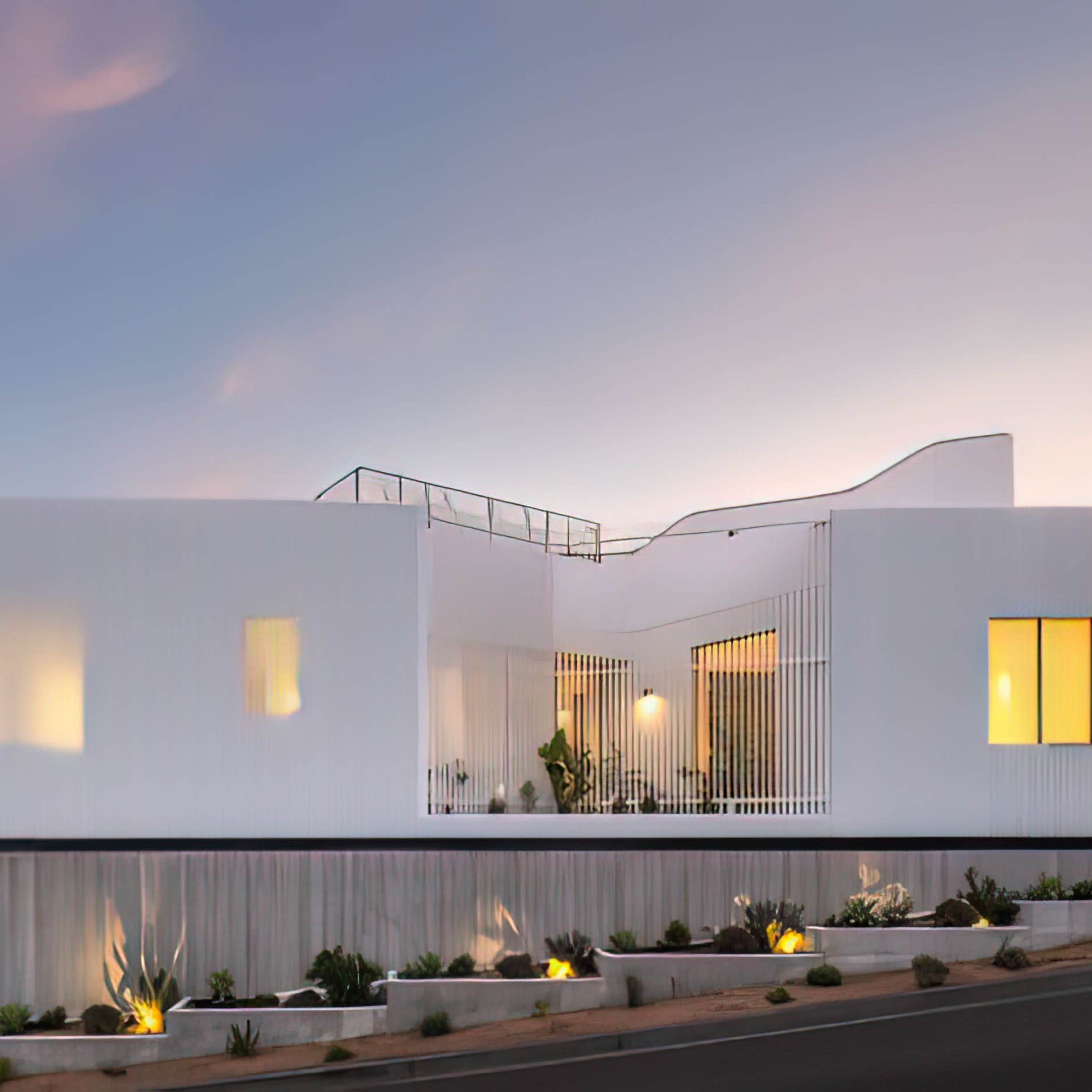A modern white house with large windows sits on a hillside, illuminated against a twilight sky.