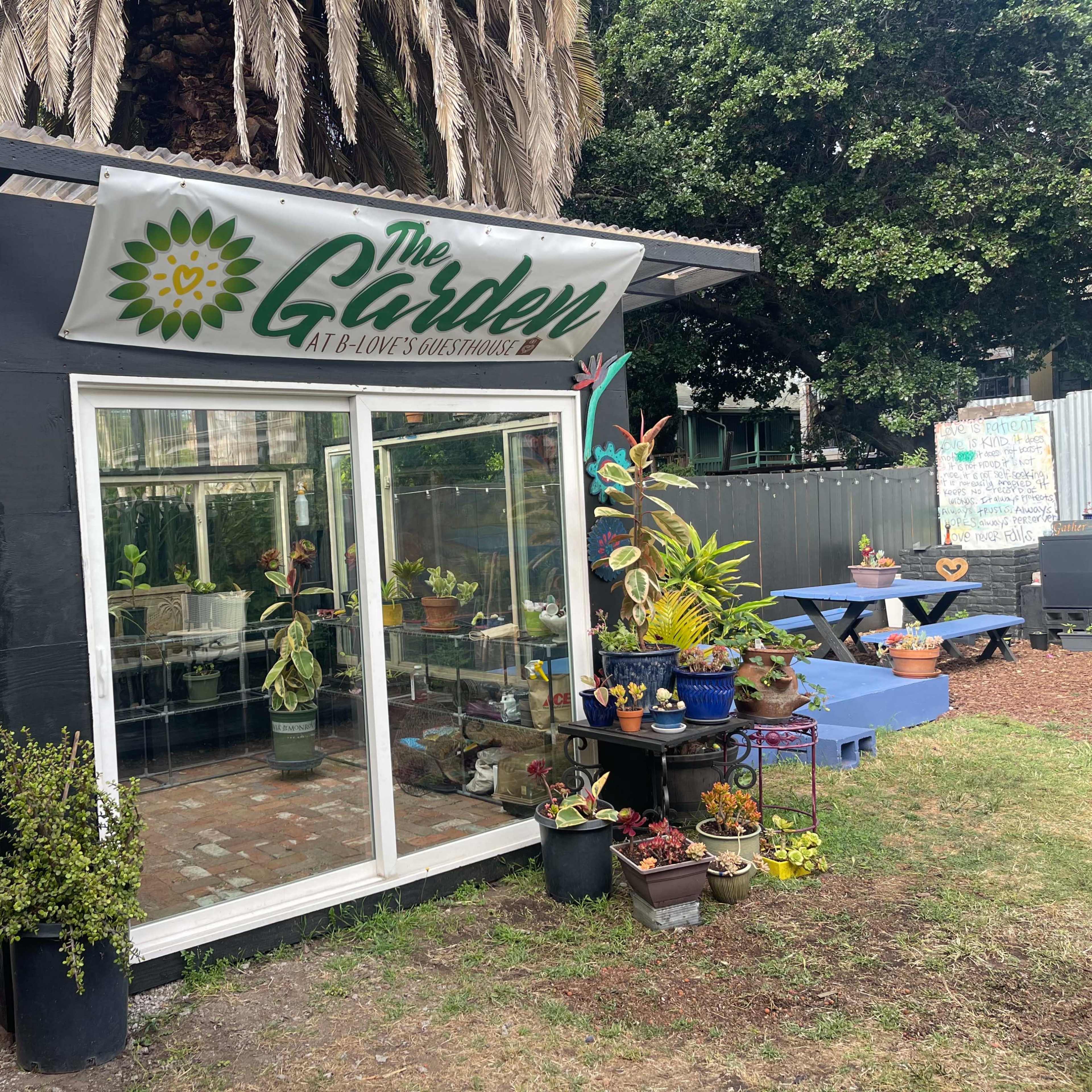 A greenhouse named "The Garden" features plants displayed inside and around it, with seating areas visible outside.