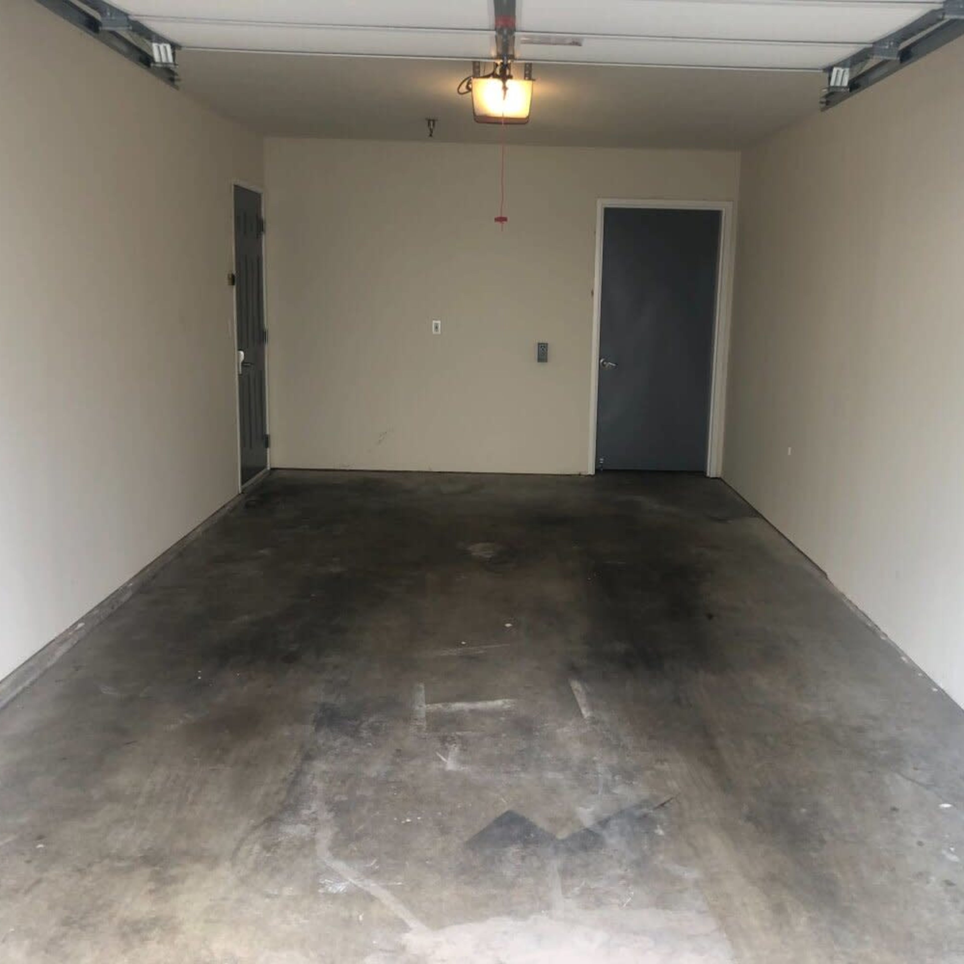 A vacant garage with a concrete floor and light gray walls.