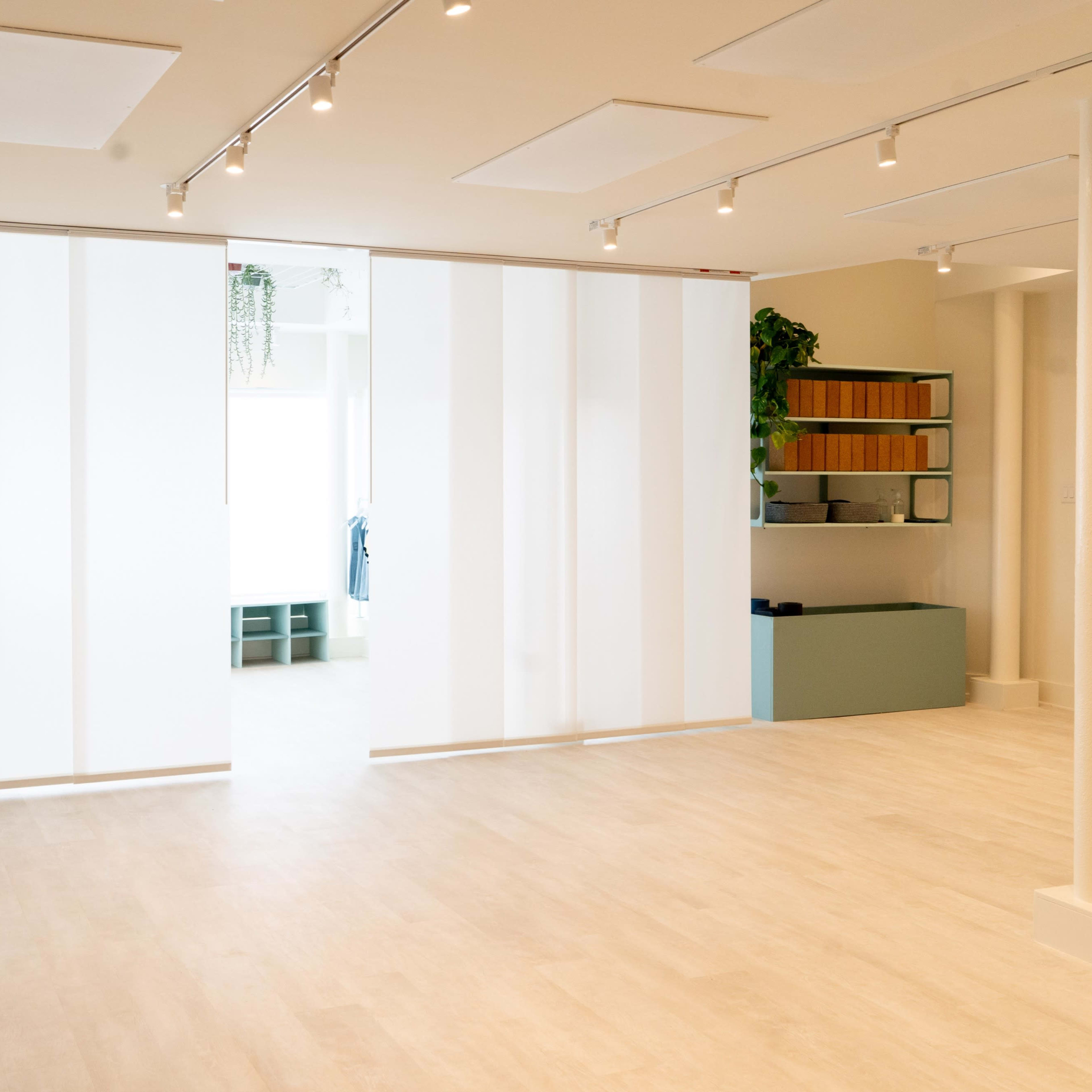 A spacious, well-lit interior with a large, frosted glass partition and minimalist furnishings.