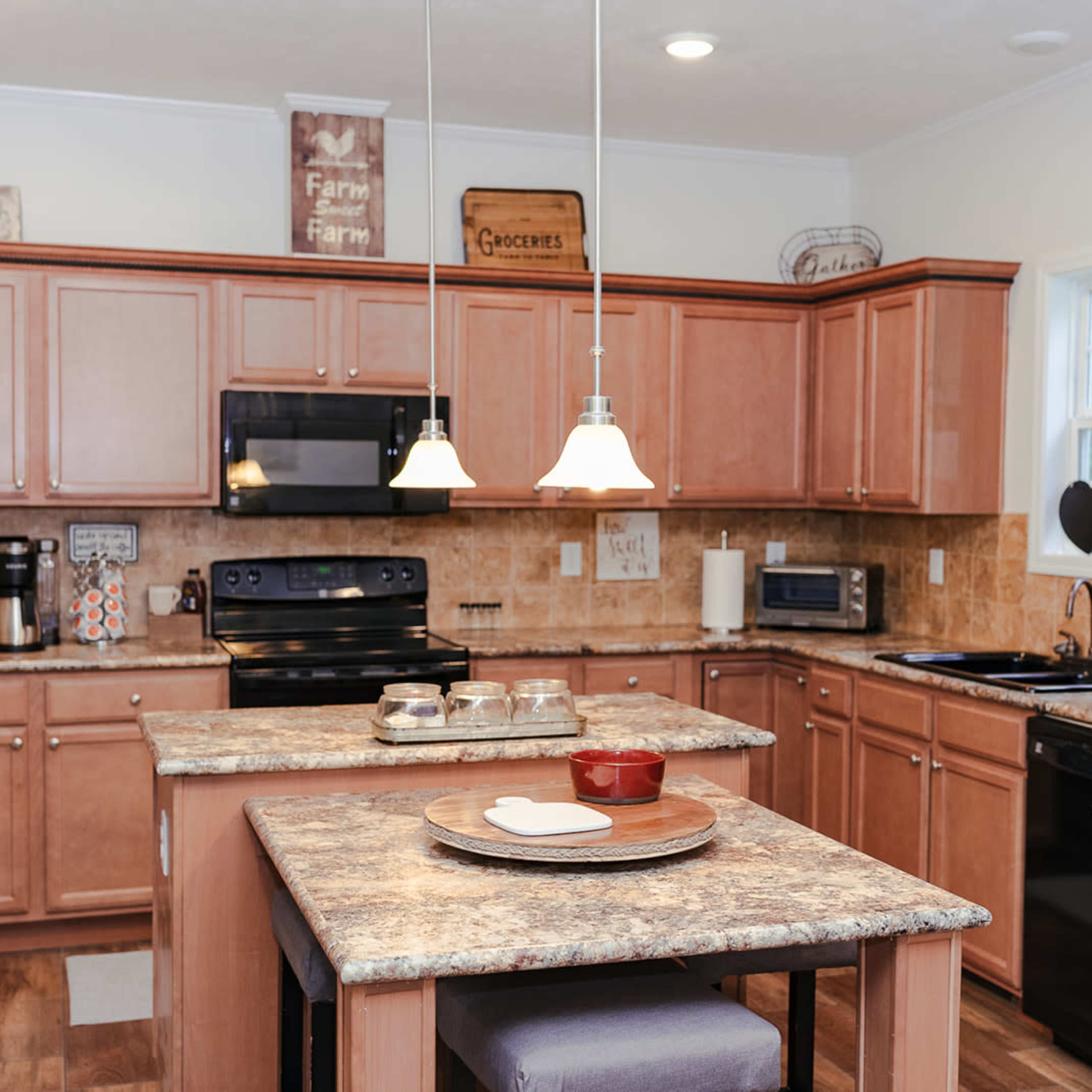 The kitchen features wooden cabinets with a central island, modern appliances, and pendant lighting.