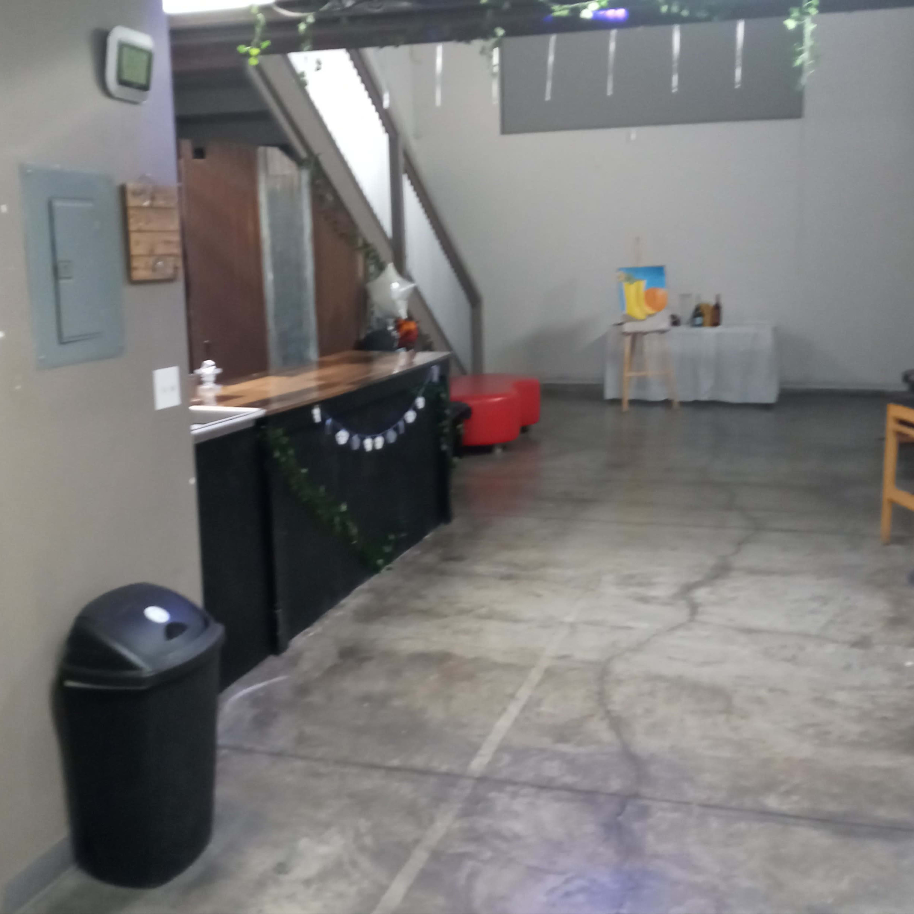 A spacious indoor area with a bar, seating, and restrooms to the left.