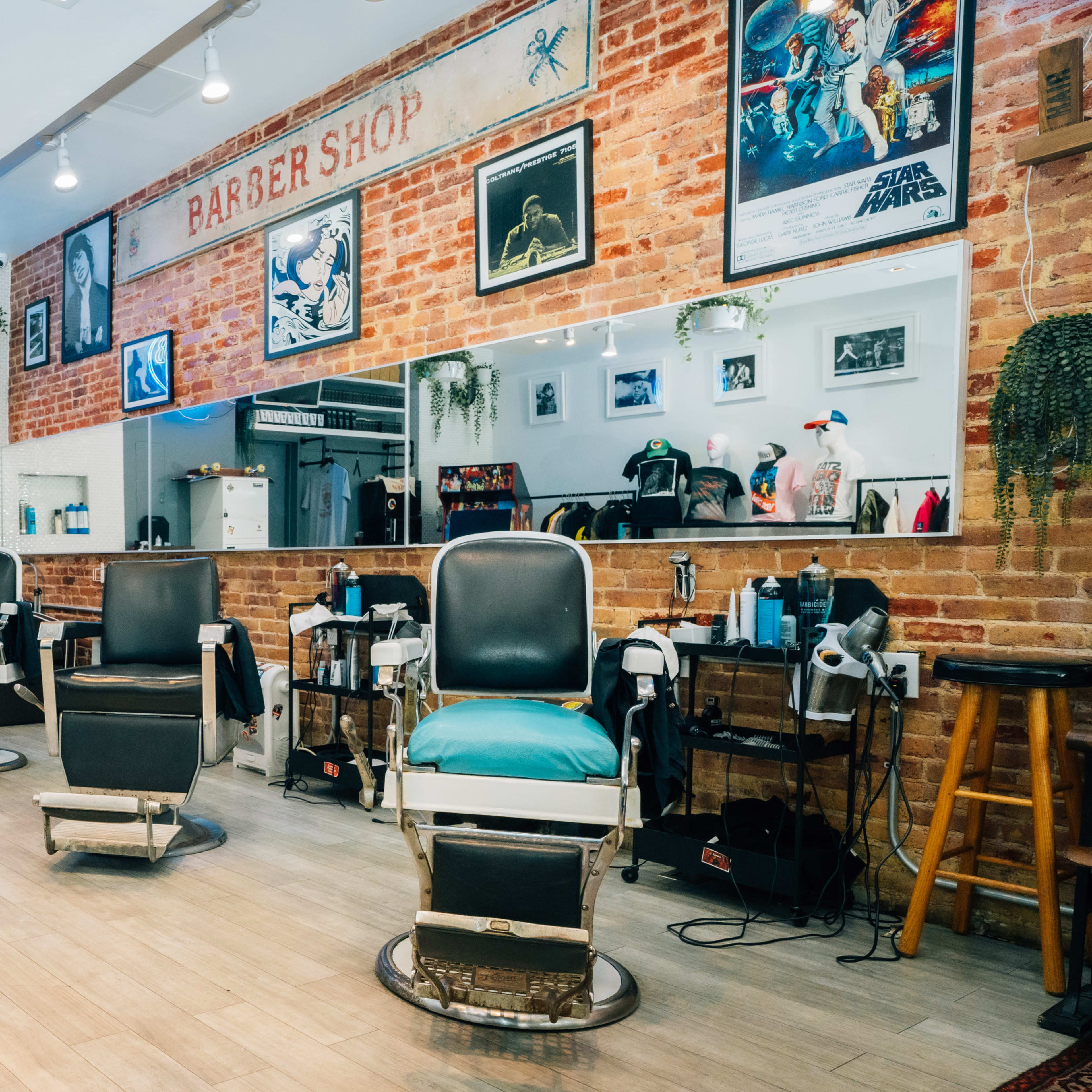A barbershop interior with three vintage barber chairs, a brick background, and various decorations on the walls.
