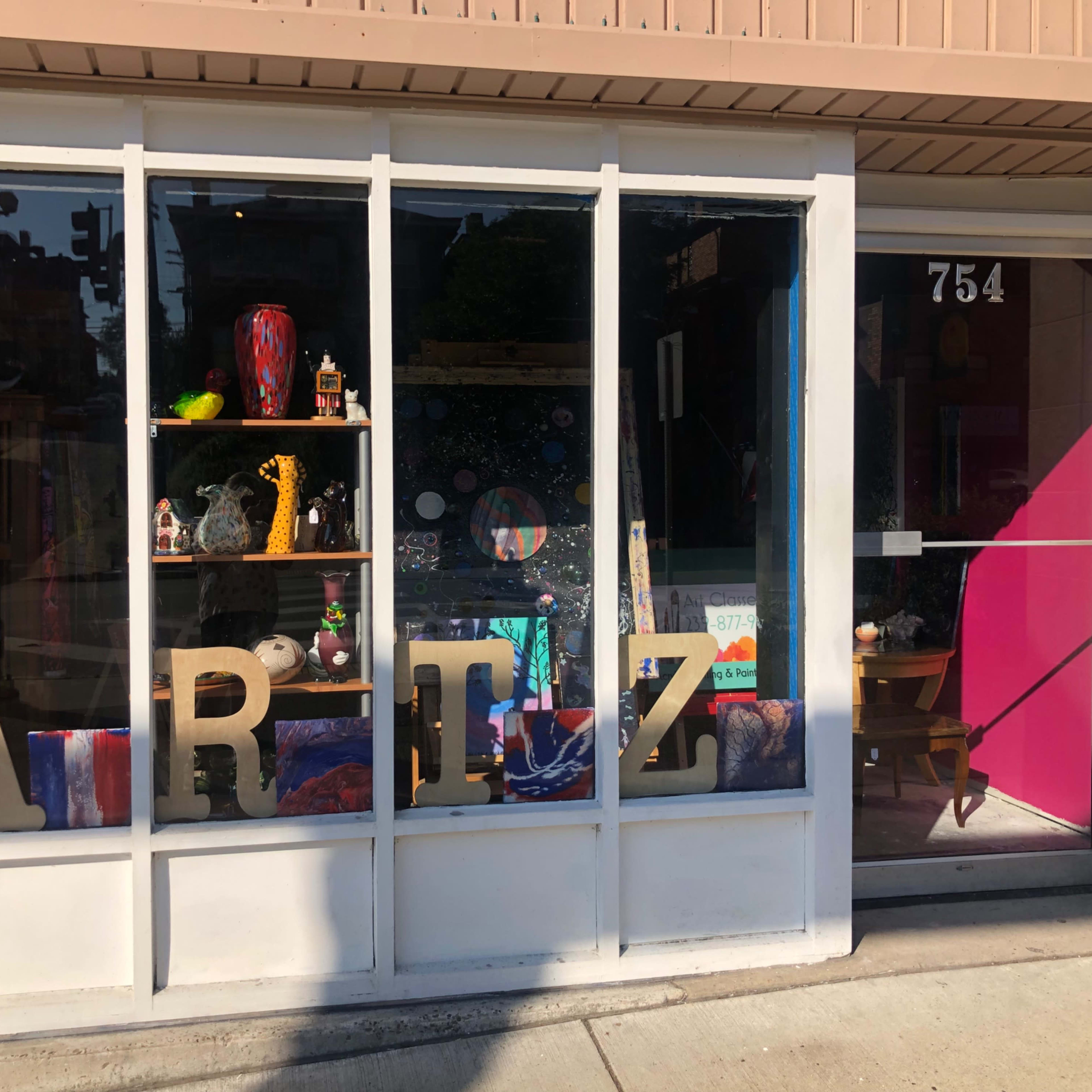The storefront features large letters spelling "ARTZ" and showcases various colorful items and decorations in the display window.
