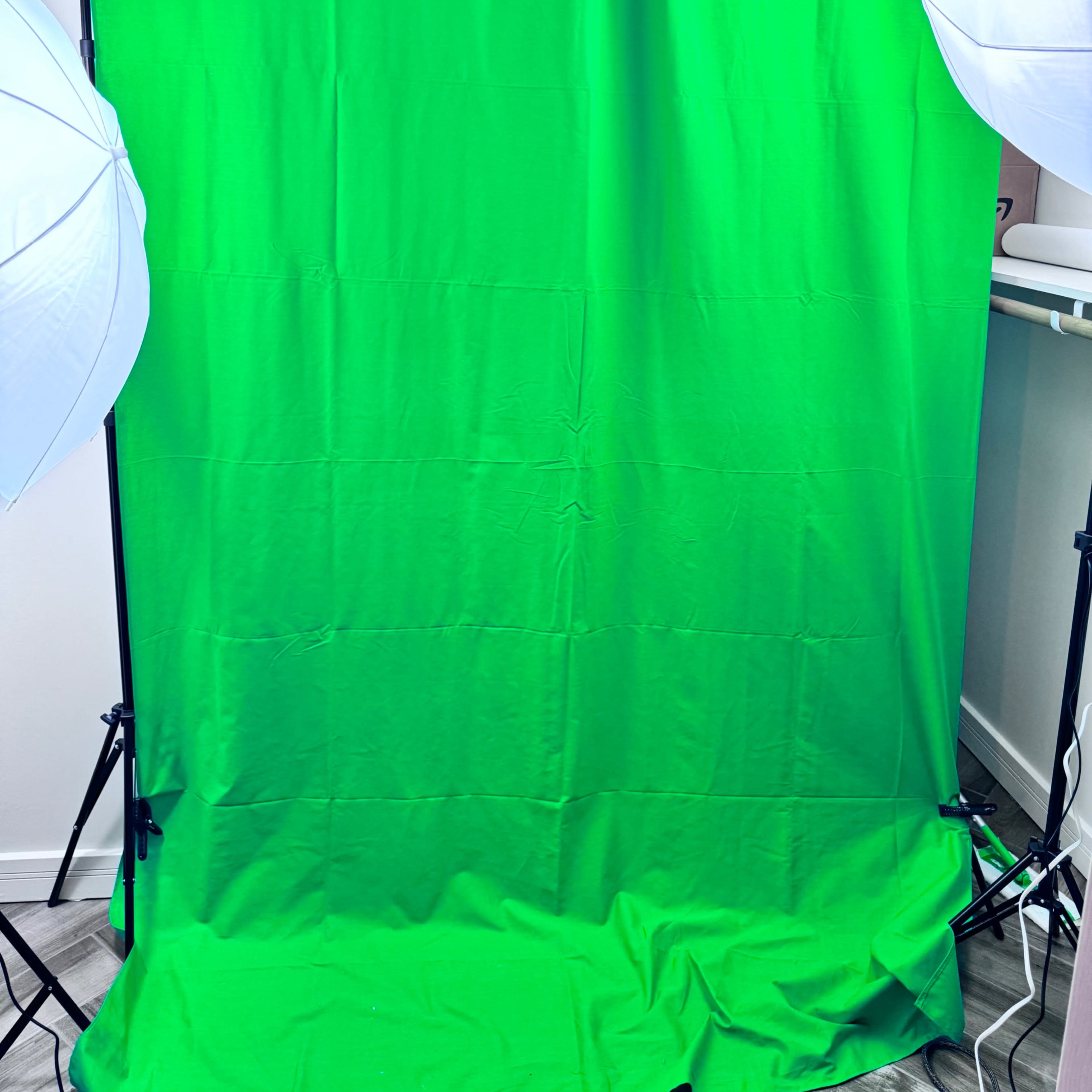A green backdrop with two softbox lights positioned on either side.