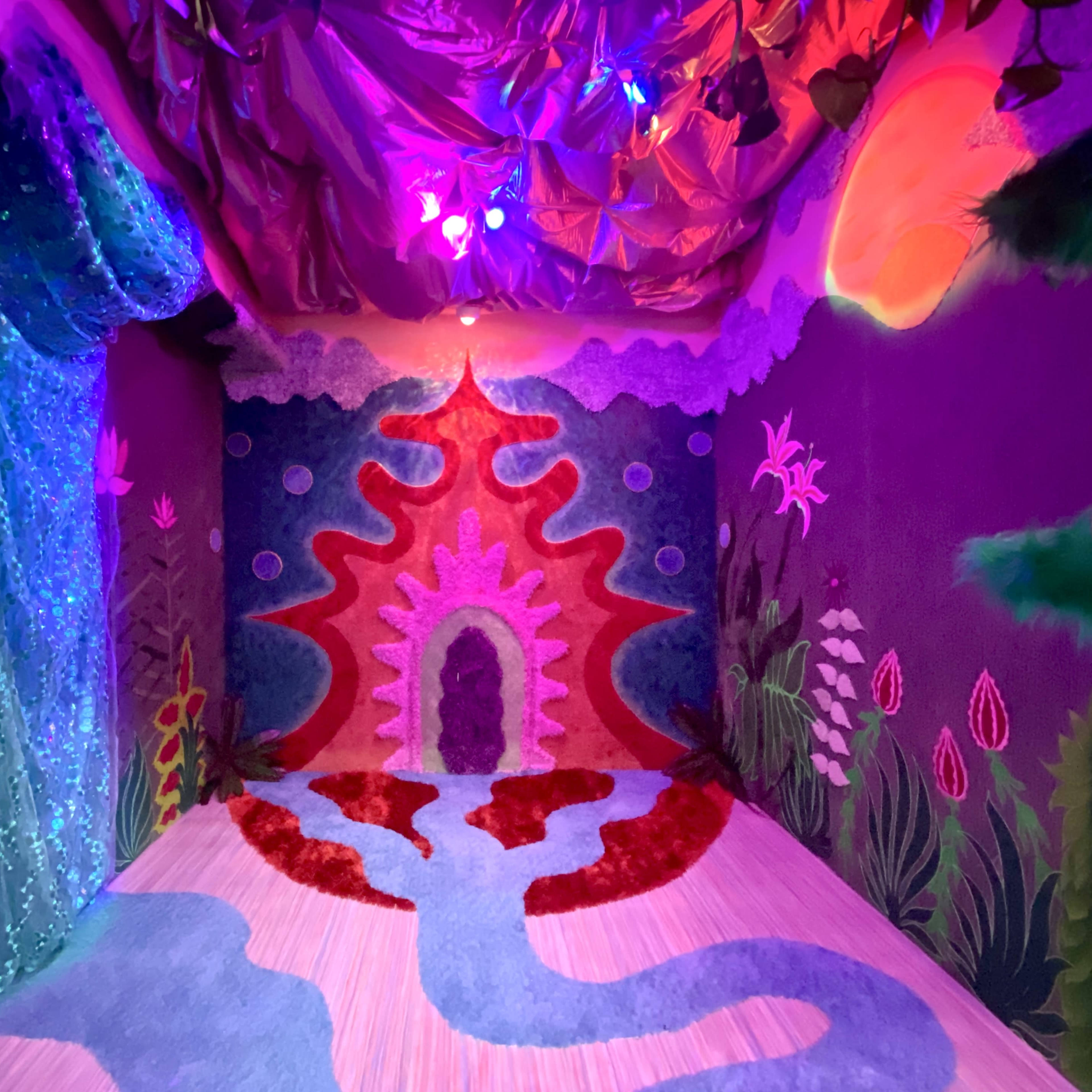A vibrant, whimsical interior room decorated with colorful, textured wall designs and a bright, illuminated ceiling.