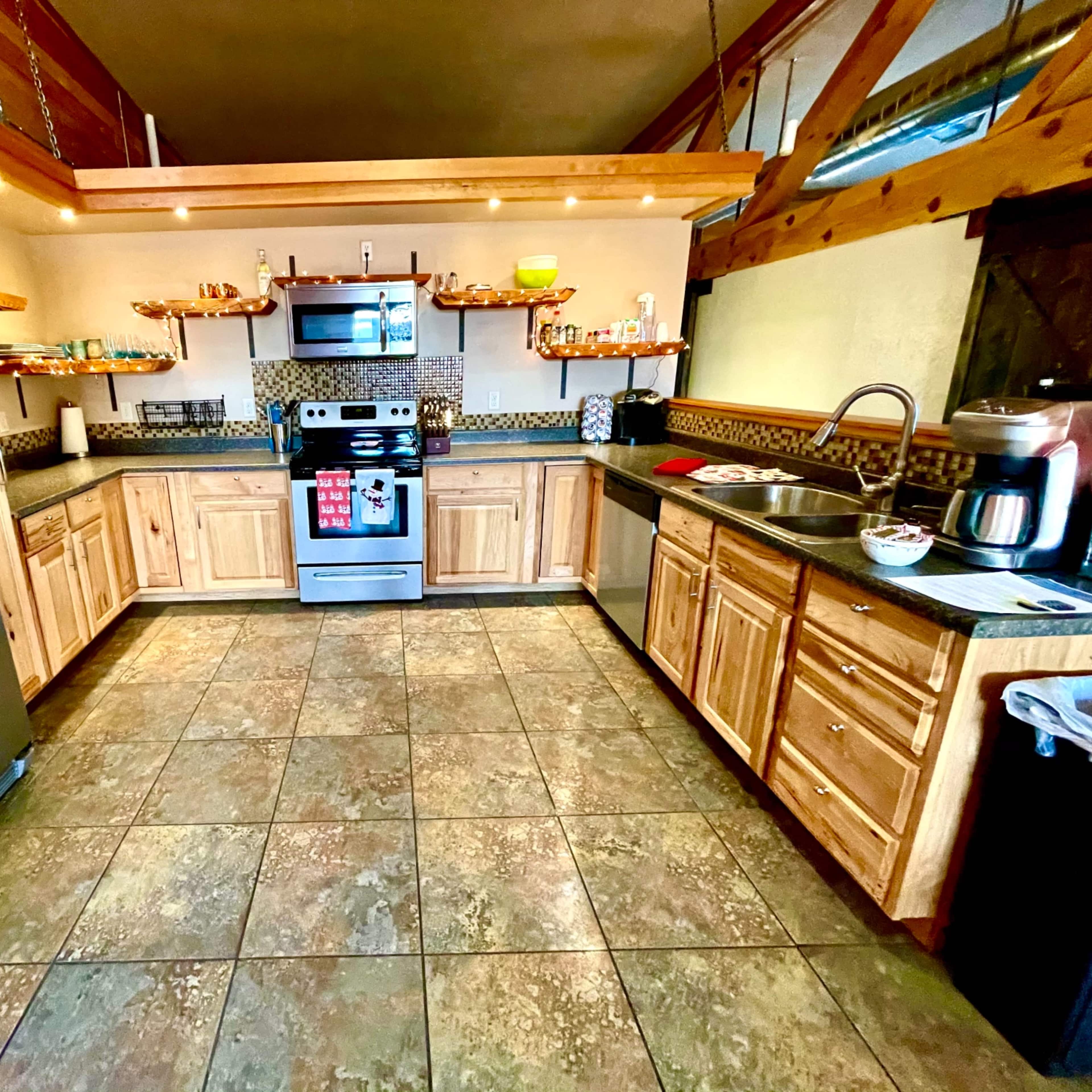 The kitchen features wooden cabinetry, stainless steel appliances, and a central island with various cooking items displayed.