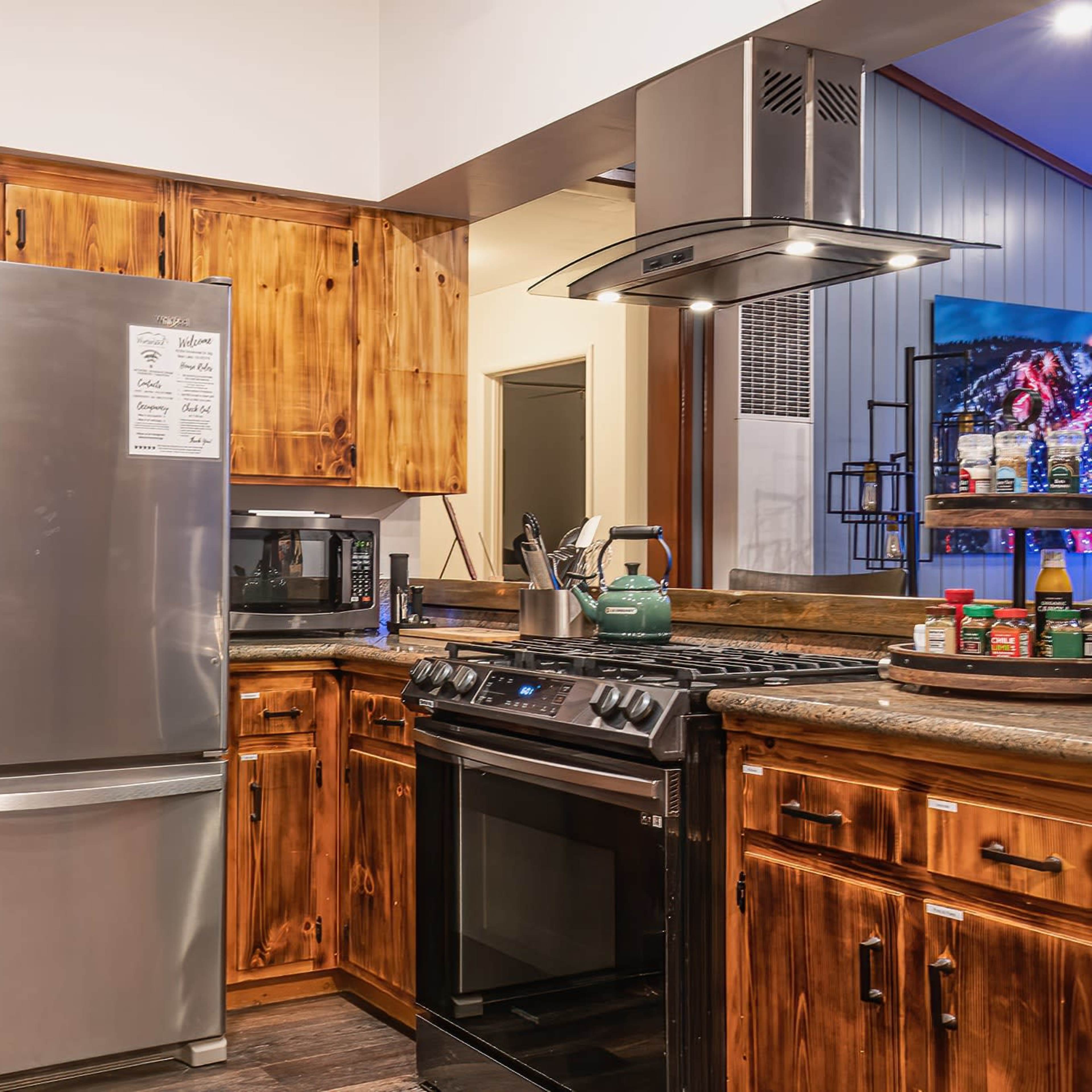 A modern kitchen features wooden cabinets, stainless steel appliances, and a spacious countertop.