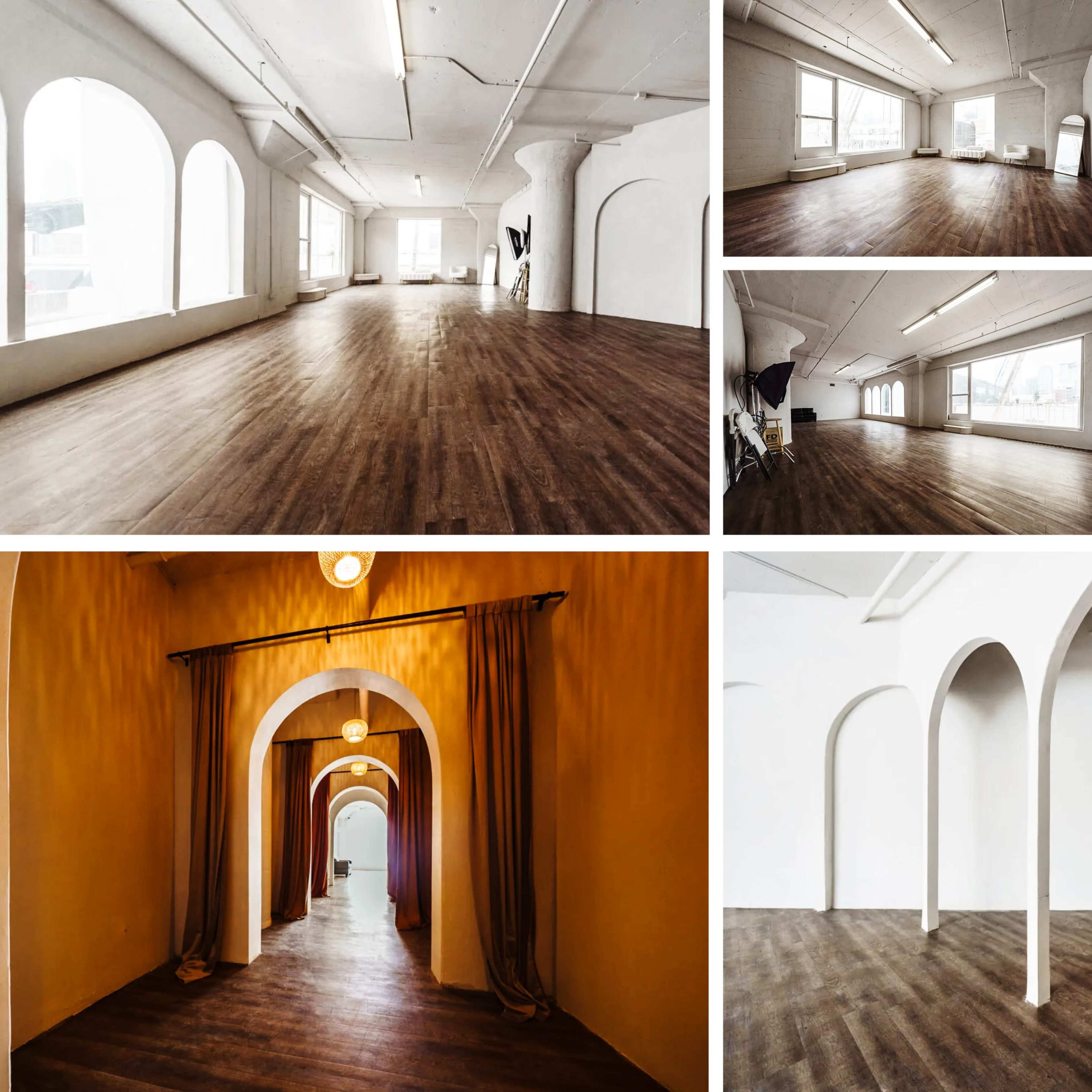 A spacious, well-lit studio with wooden flooring, featuring arched doorways and large windows.