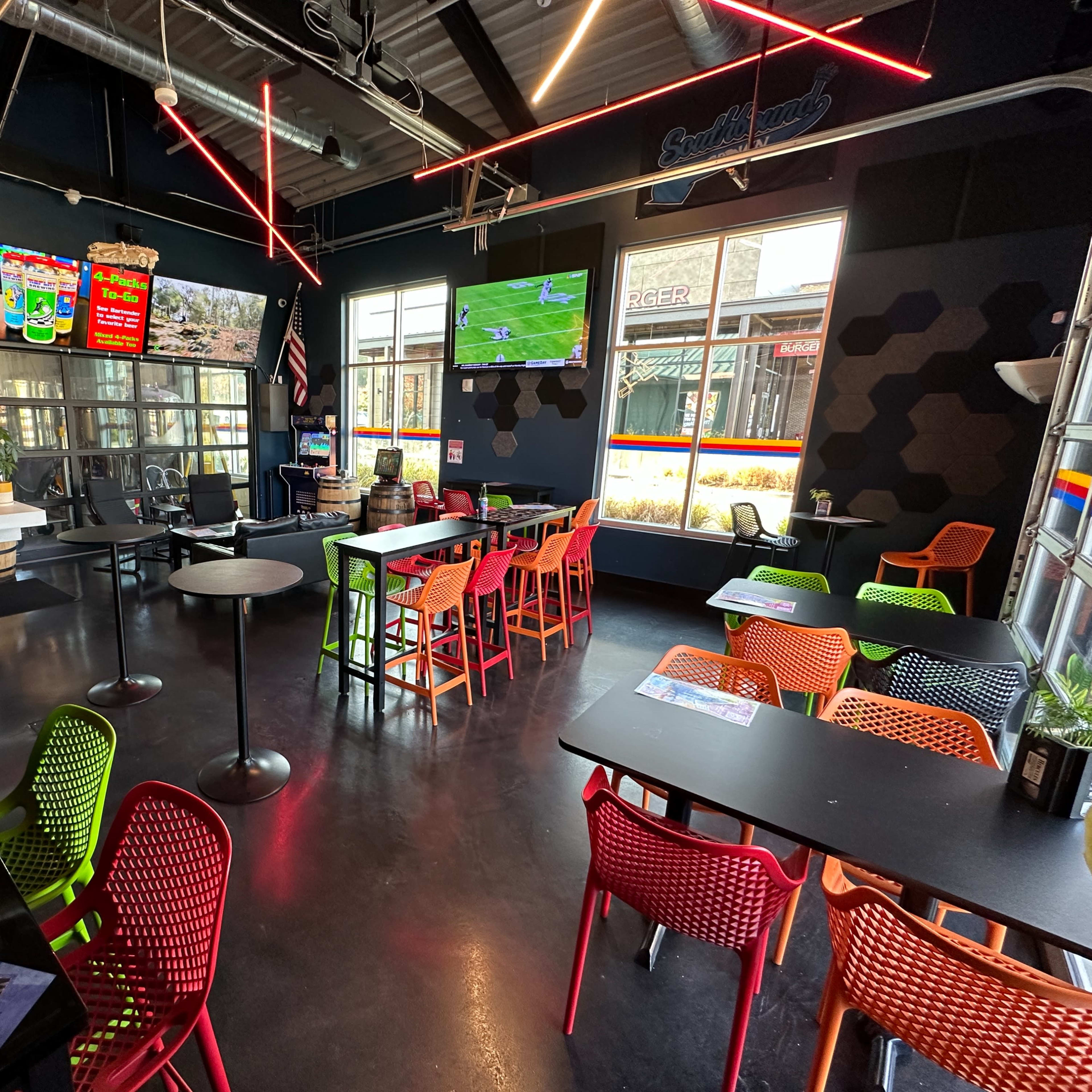 A modern café with colorful seating, a service counter displaying various items, and large windows providing natural light.