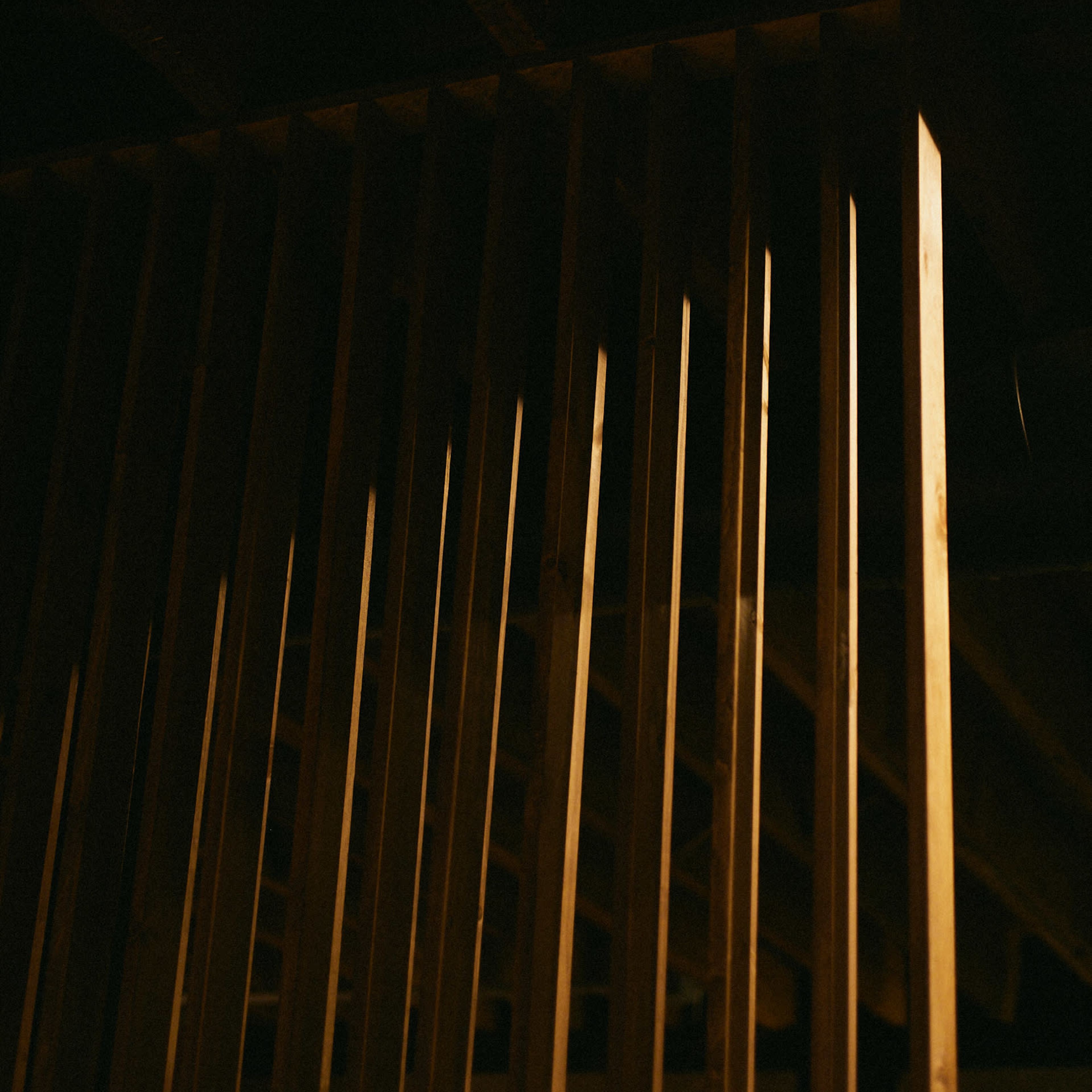 Wooden beams illuminated in a dimly lit setting.