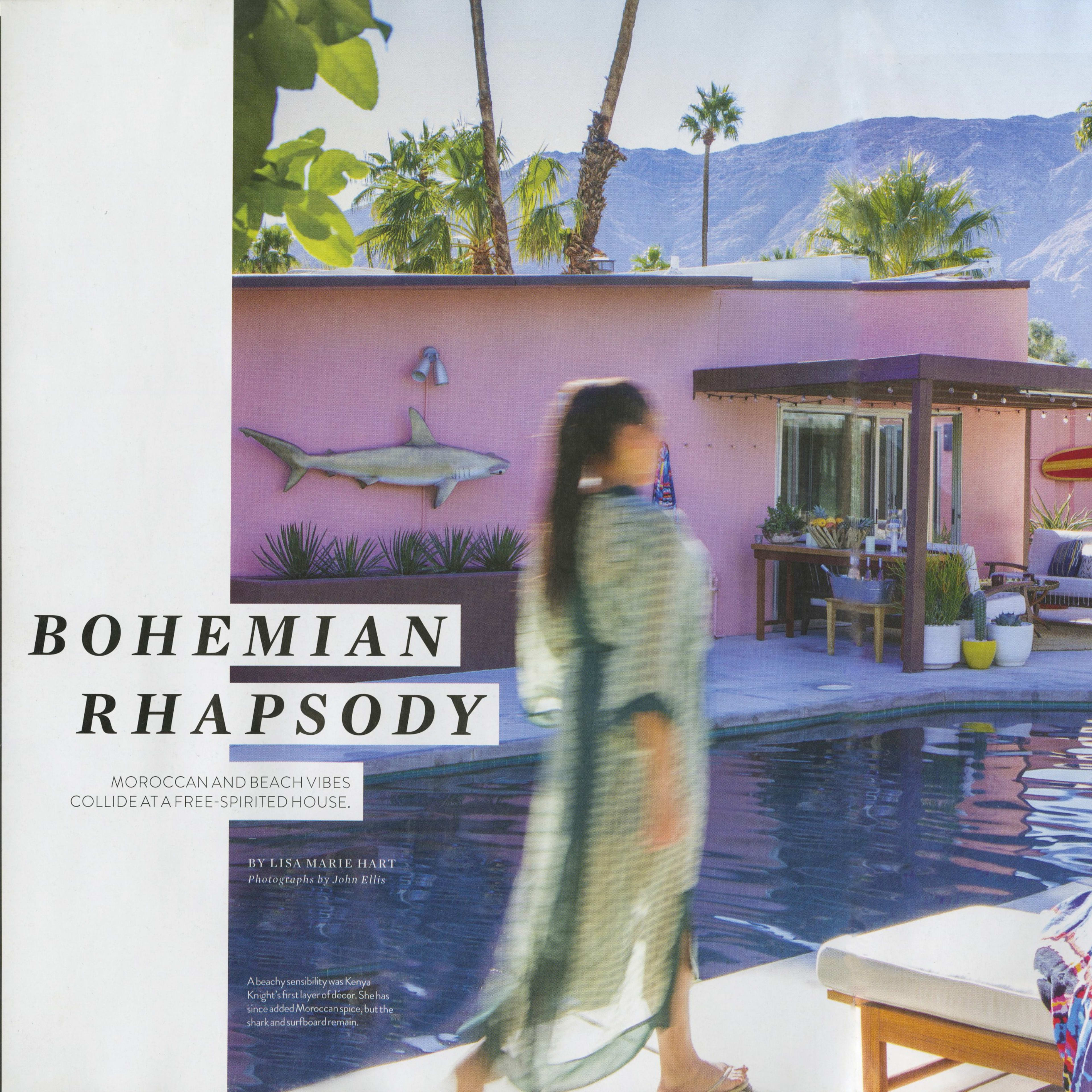A vibrant poolside scene with palm trees, a pink house, and sun loungers, set against a backdrop of mountains.