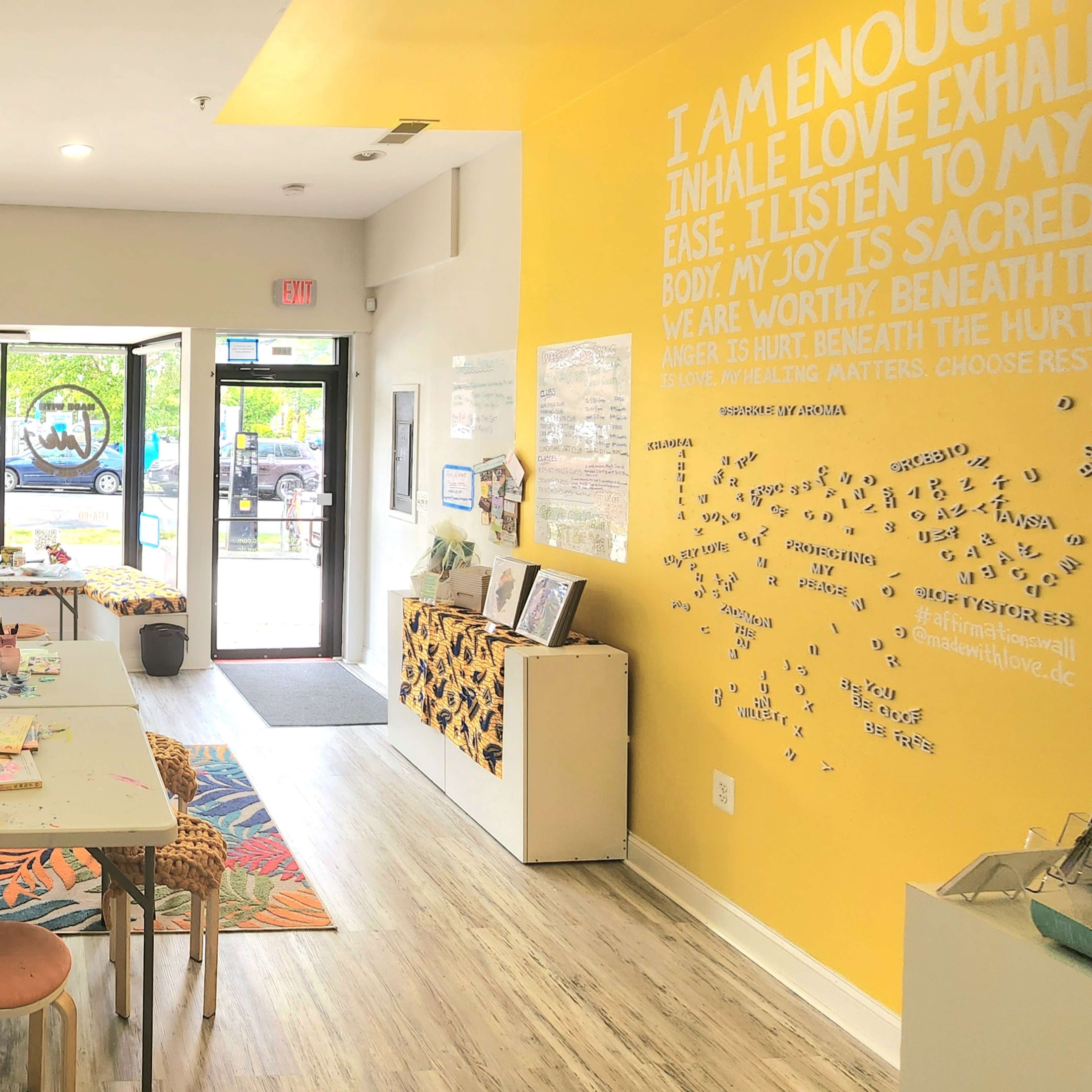 A bright interior of a wellness shop with shelves filled with products, a central table, and motivational quotes on the walls.