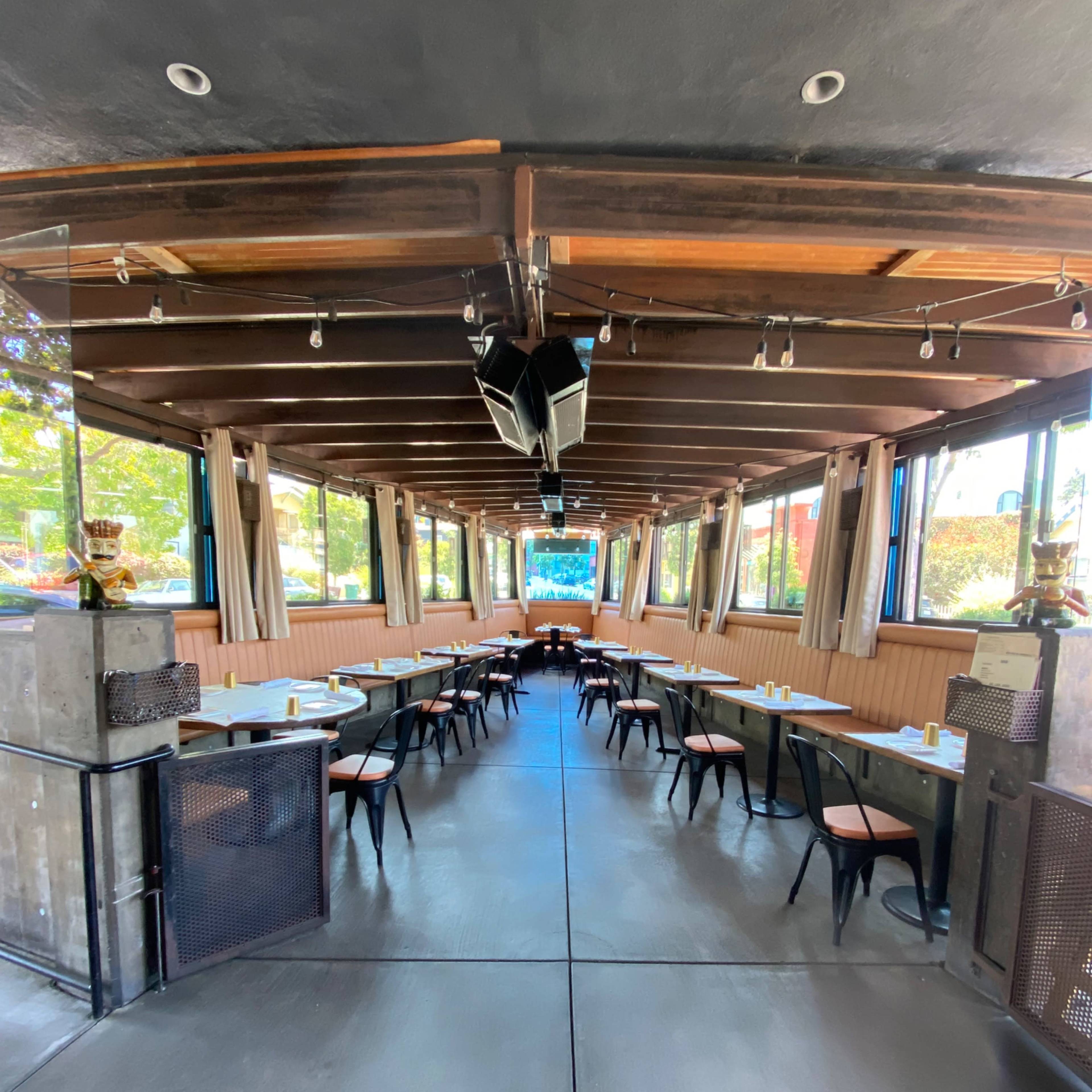 A restaurant interior featuring rows of tables and chairs arranged neatly in a bright, open space with large windows.