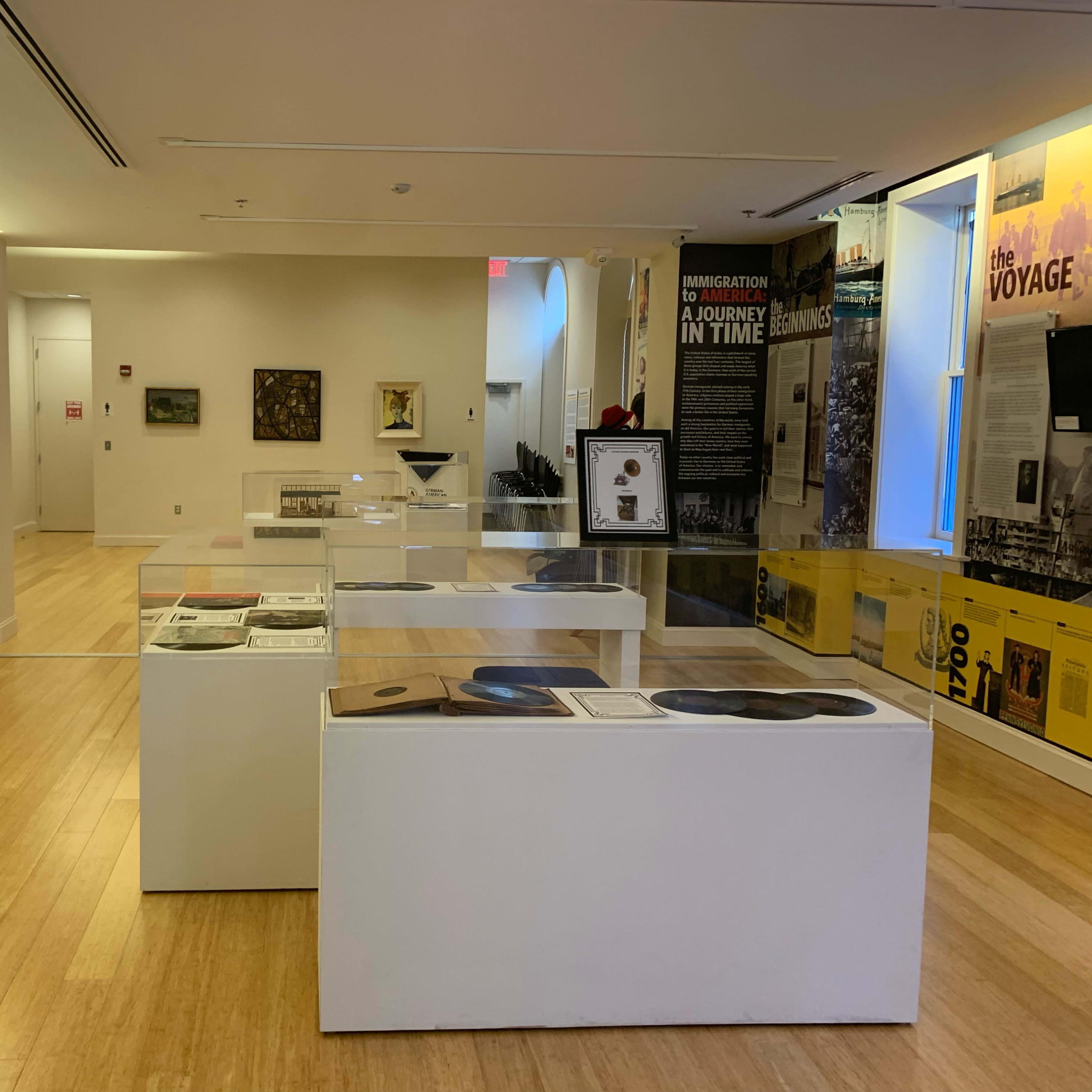 An exhibition space with display cases featuring various artifacts and informational panels in a museum setting.
