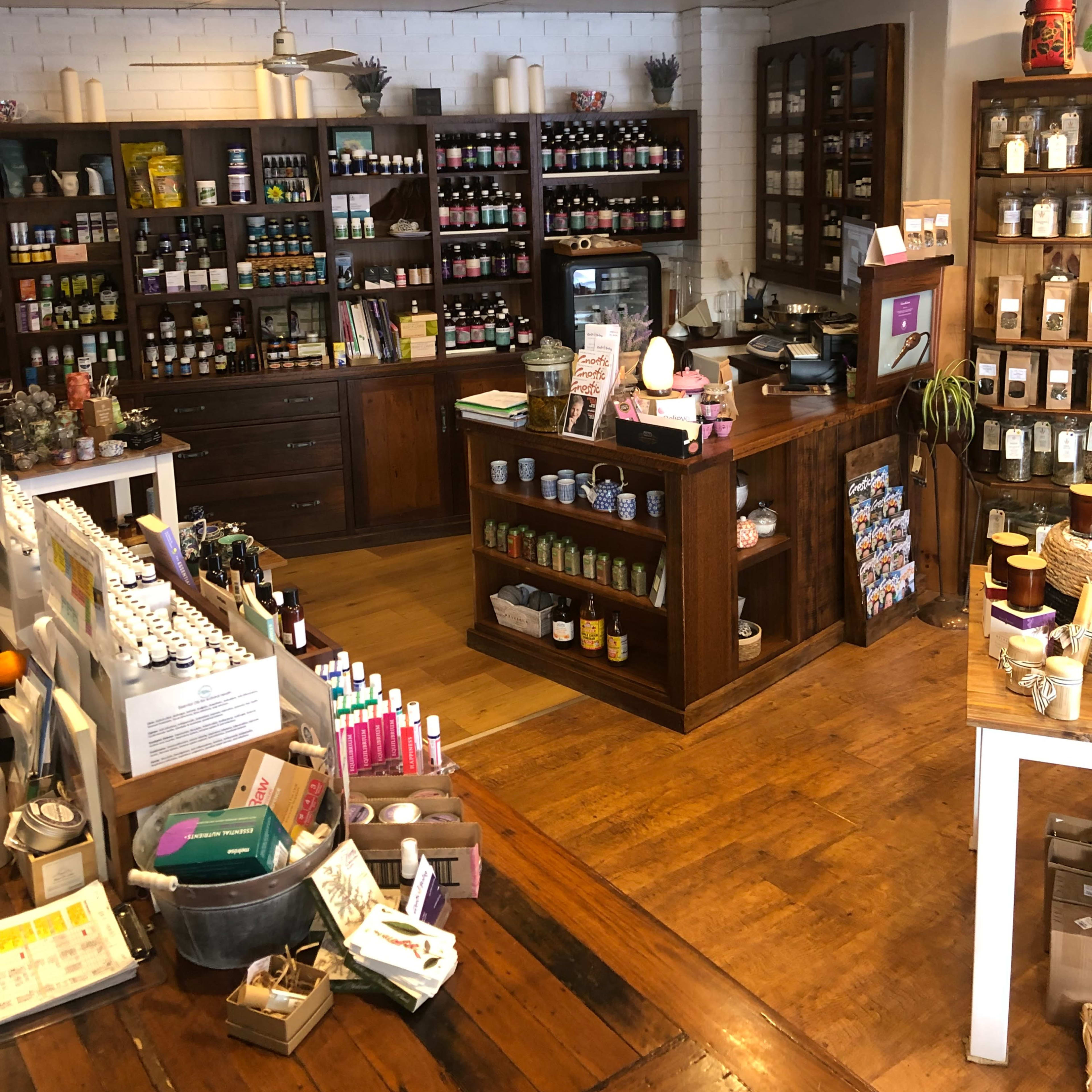 A well-organized shop interior featuring wooden shelves stocked with various bottles and jars of products, a counter at the front, and a warm wooden floor.