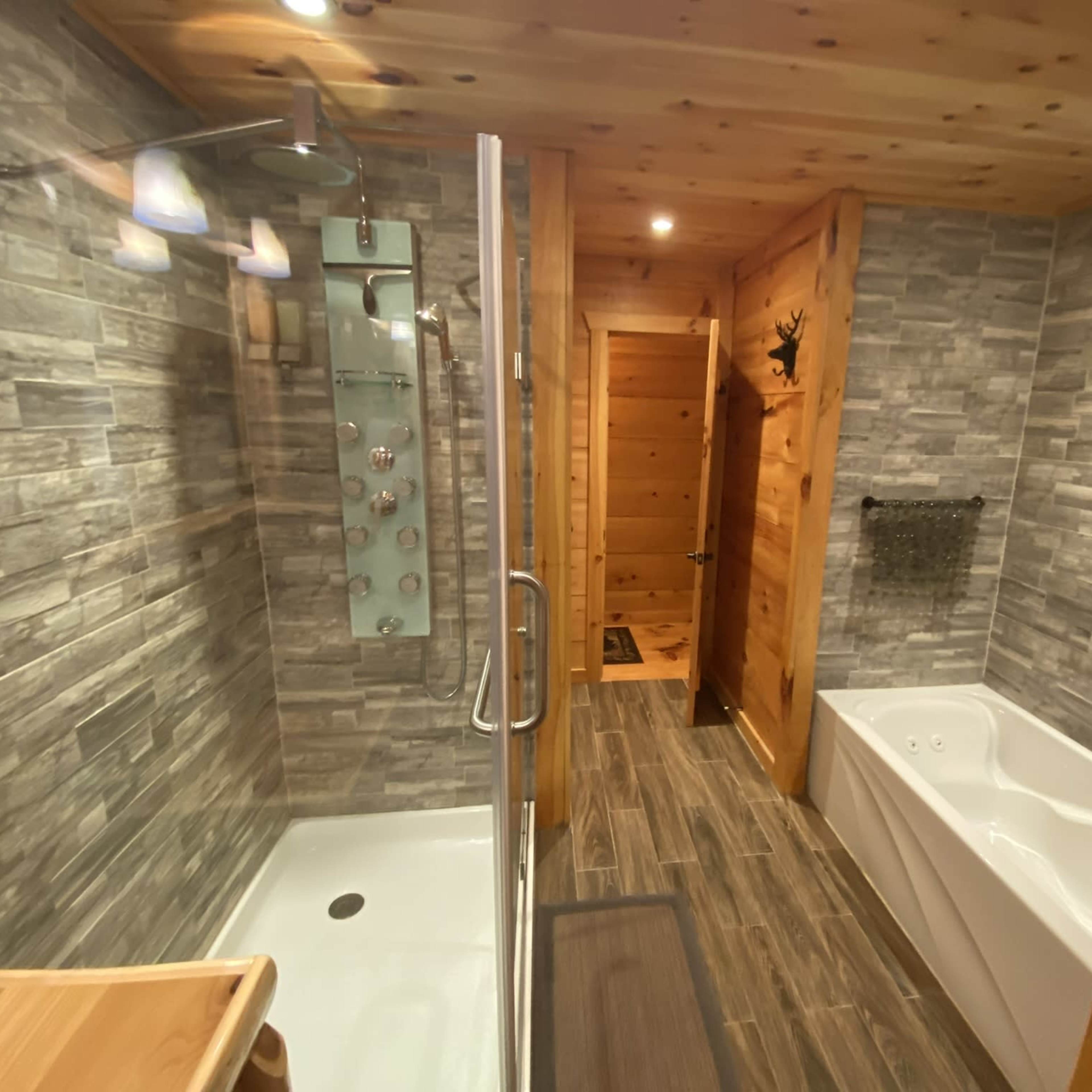 A modern bathroom featuring a glass shower enclosure, a freestanding bathtub, and wooden accents.