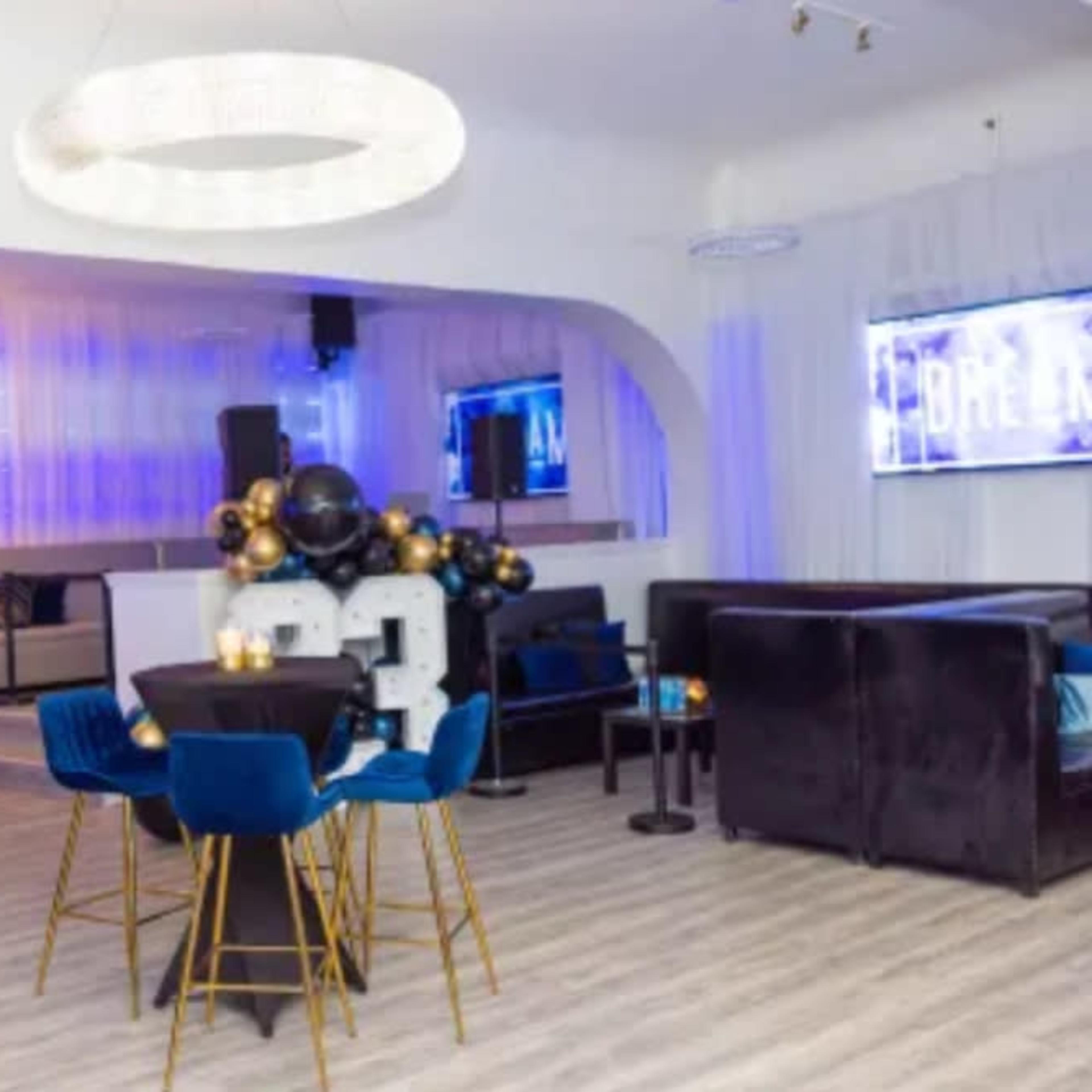An elegant party venue decorated with balloons and illuminated with soft lighting, featuring a large "2023" display.