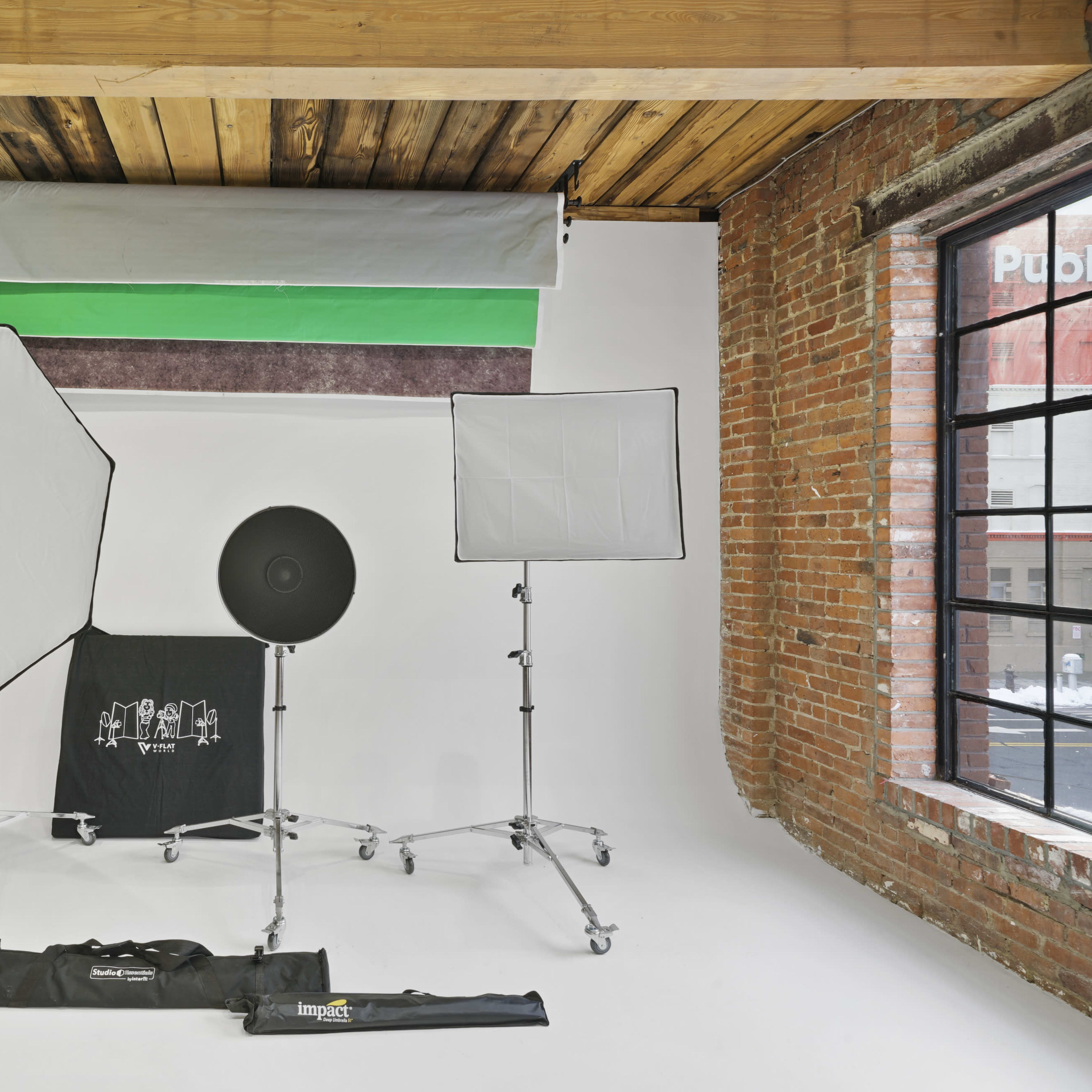 A photo studio setup with various lighting equipment, including softboxes, an octabox, a backdrop, and stands.