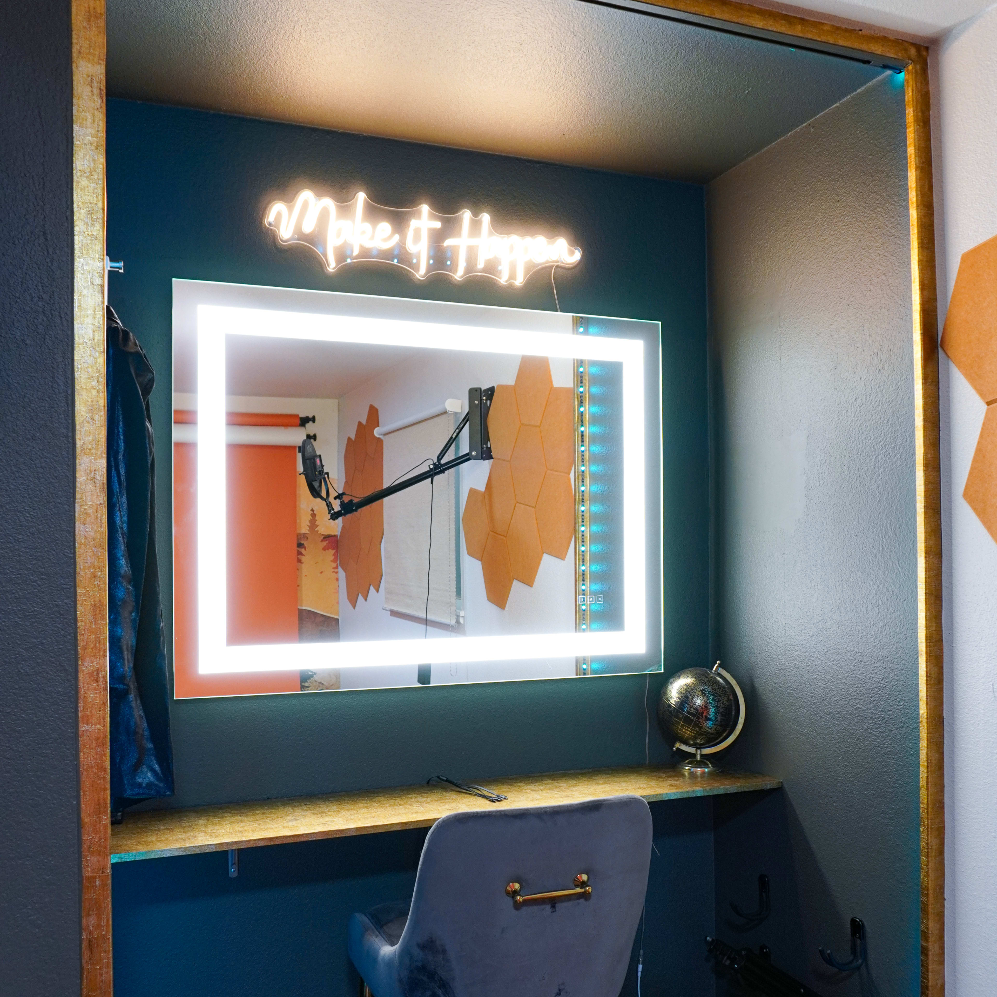 A well-lit vanity area with a glowing mirror and a chair against a blue wall, featuring hexagonal decorations and a globe.