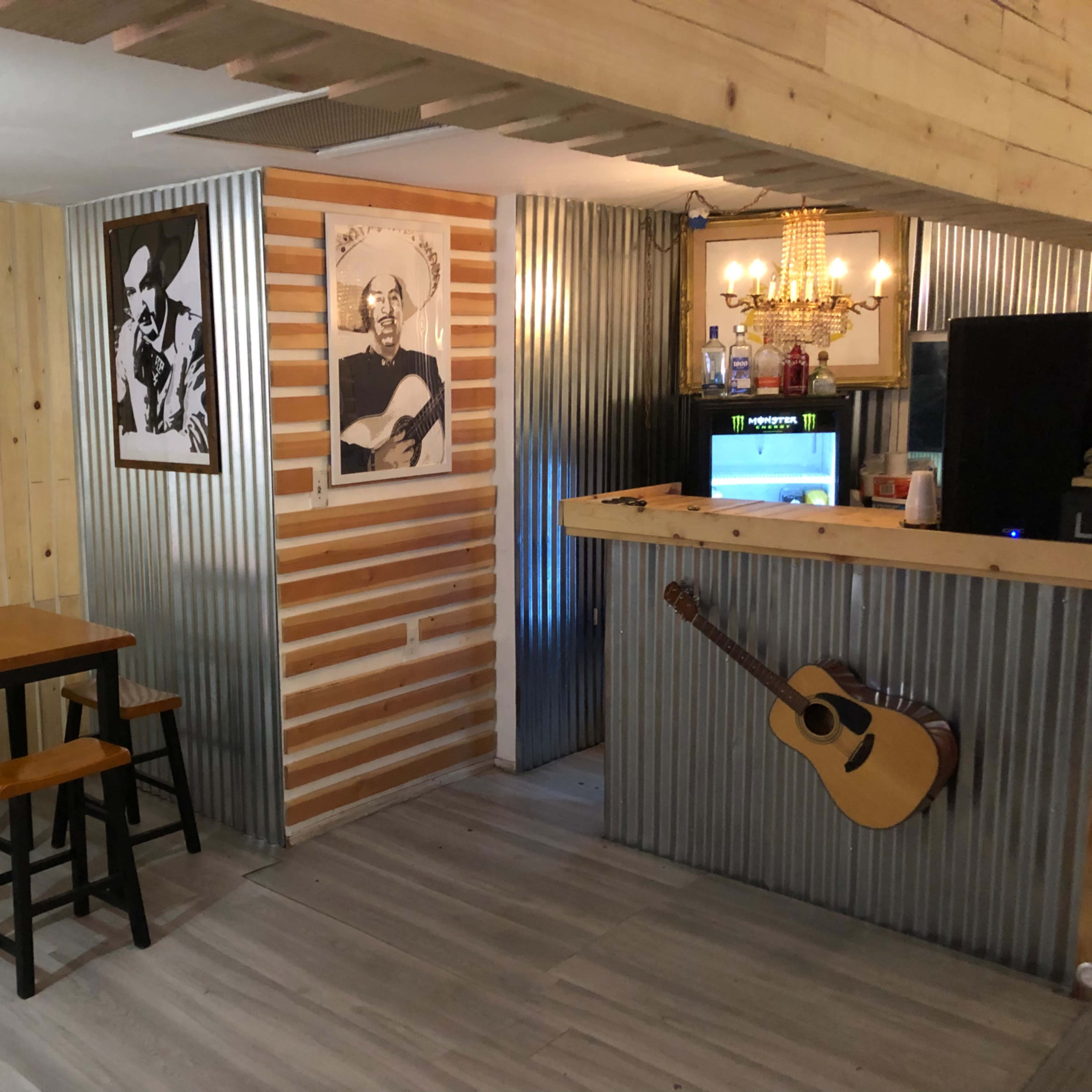 A rustic-style interior with a wooden table and chairs, metal accents, and wall decorations featuring music-themed artwork.