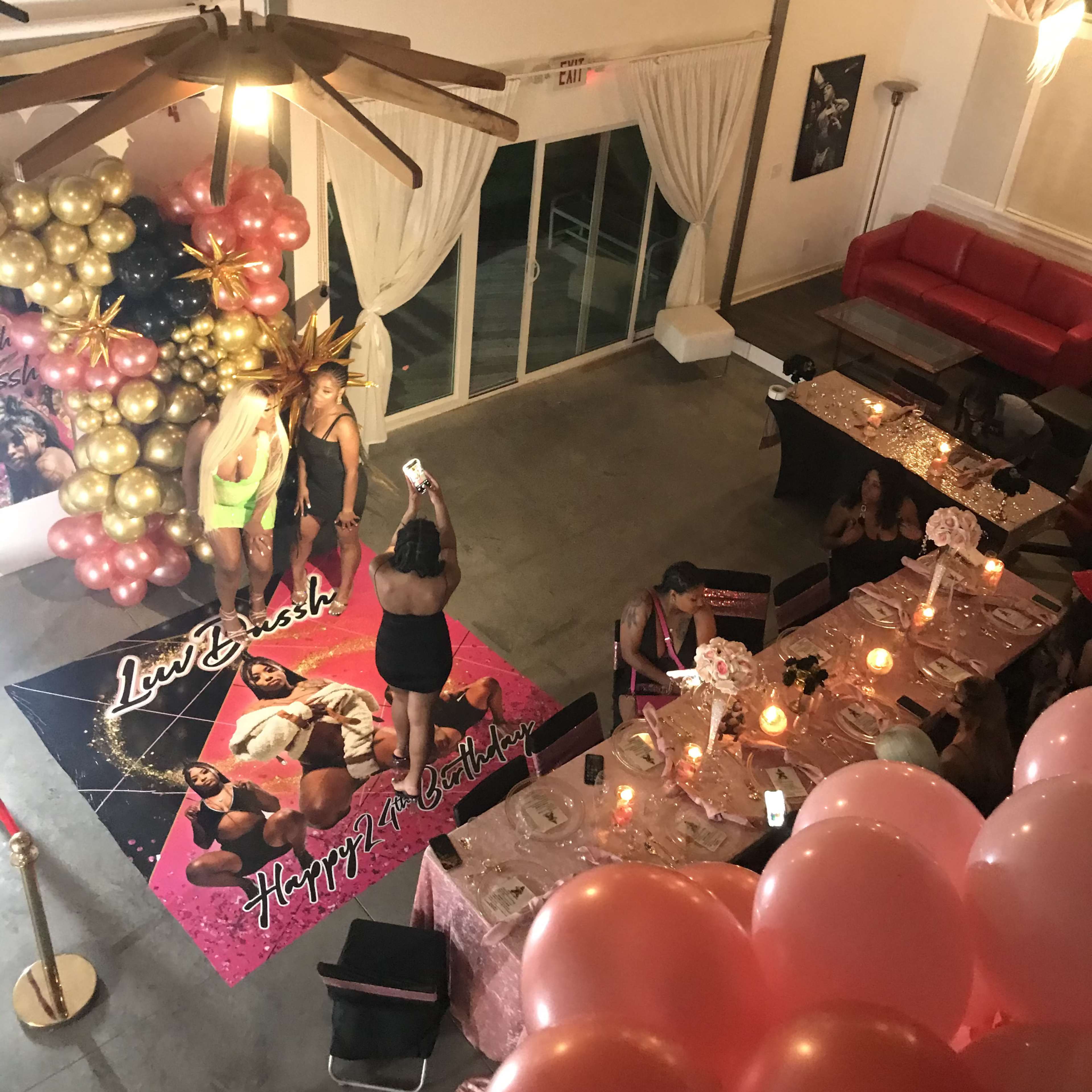 A celebration scene features guests gathered around tables decorated with balloons and a colorful backdrop, while a group poses on a themed mat.