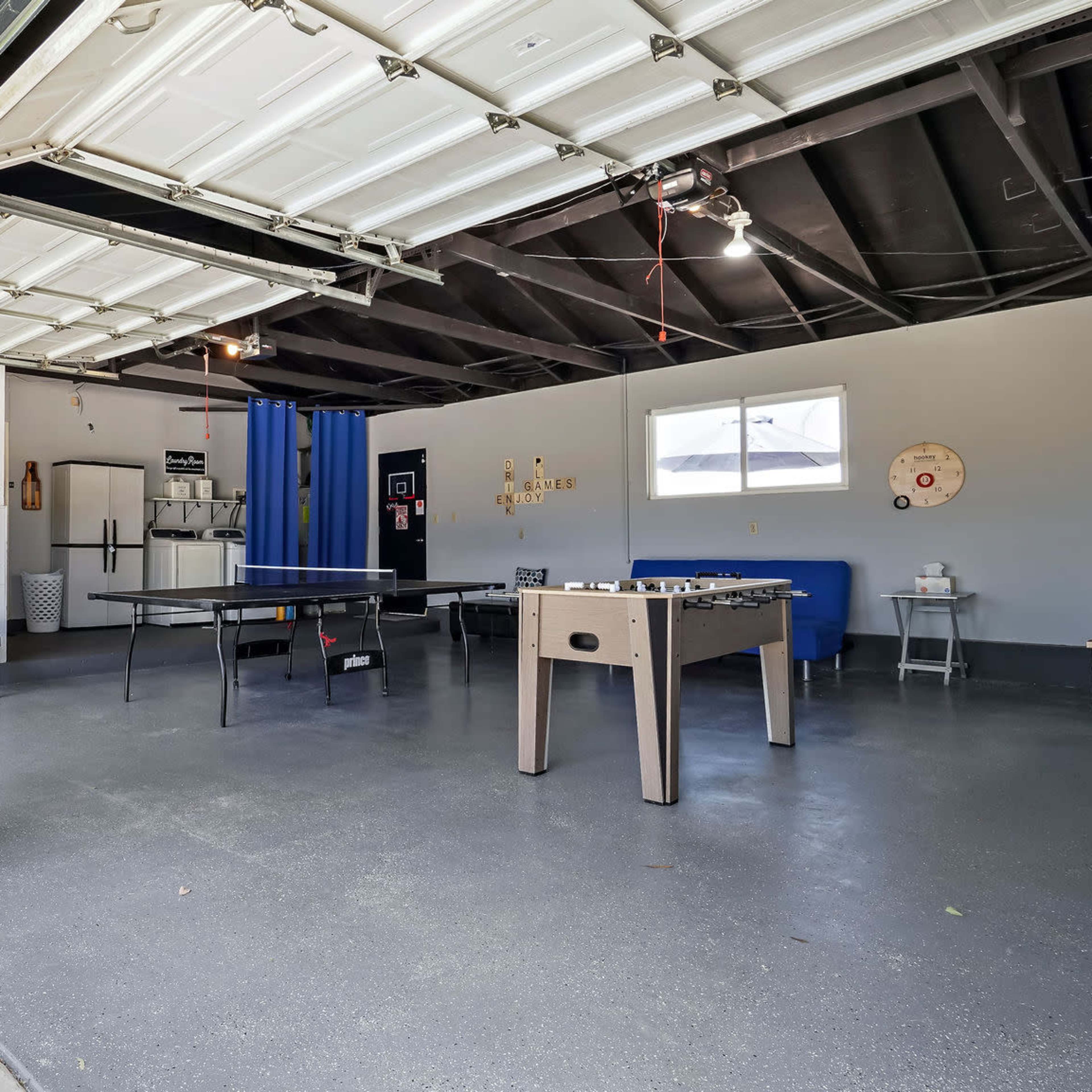 A spacious dining area features a coffee bar, a dining table with chairs, and a well-decorated wall showcasing various signs and shelving.