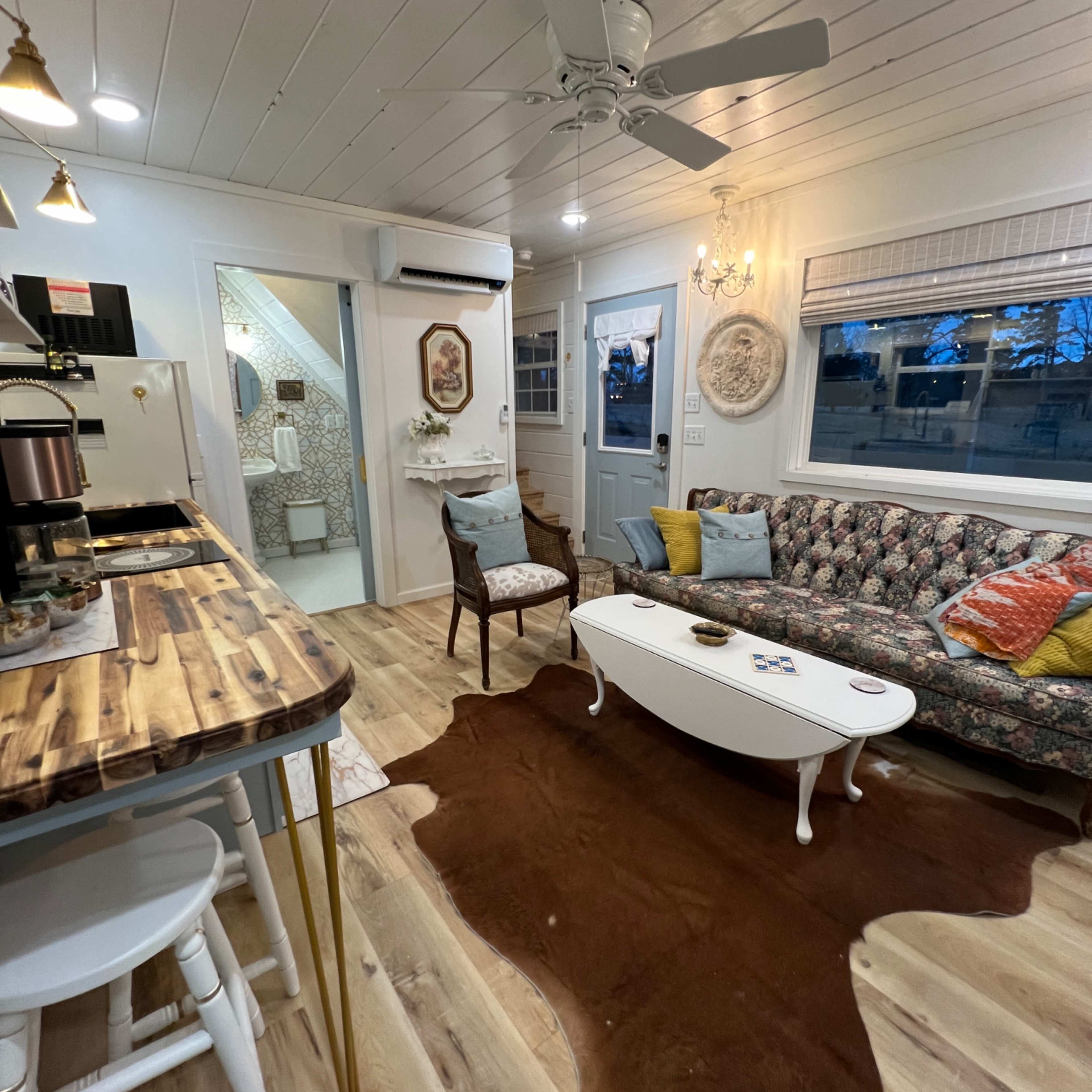 A cozy living area with a patterned sofa, wooden coffee table, and a decorative rug on the floor.