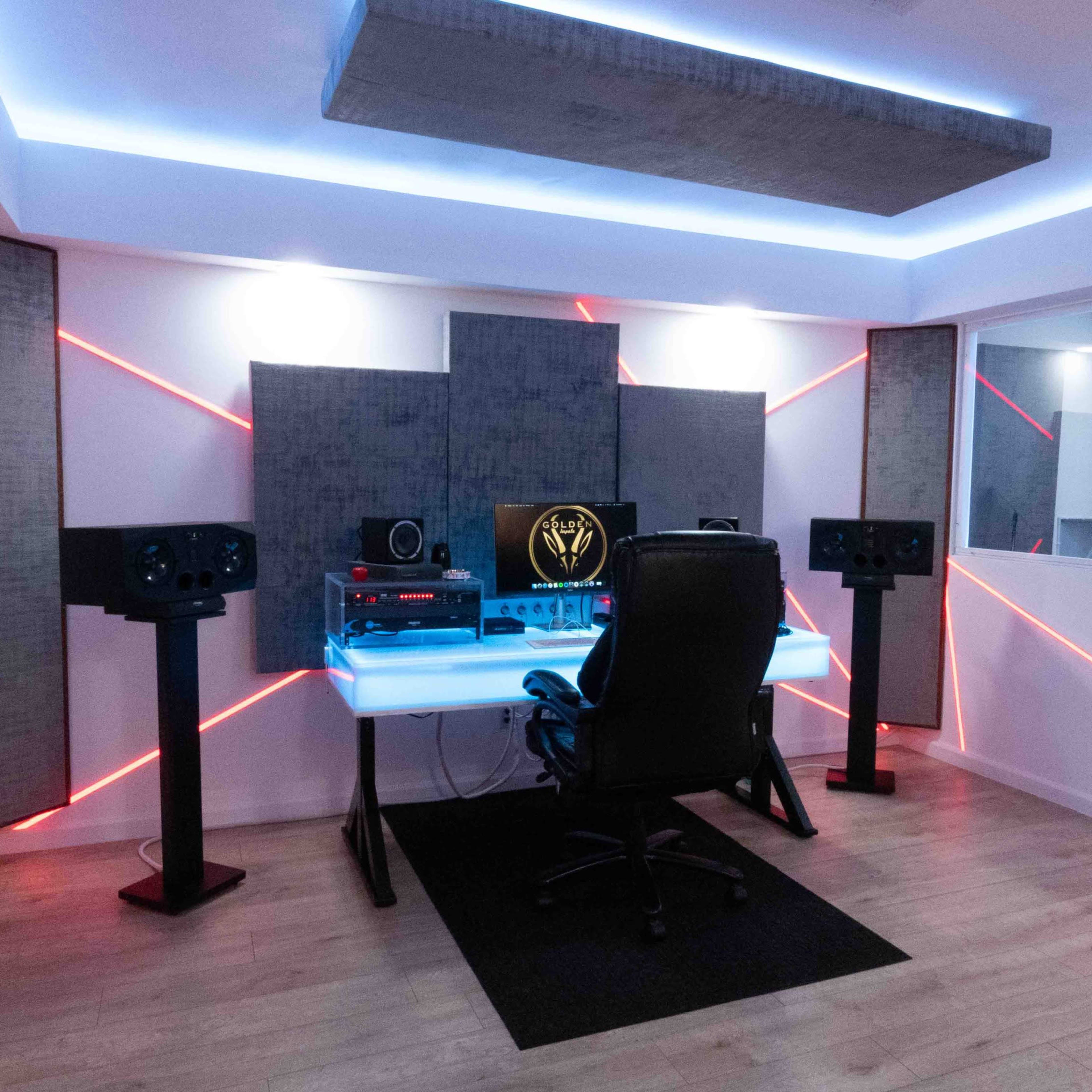 A modern music studio features a central mixing desk, sound monitors, and wall treatments with LED lighting.