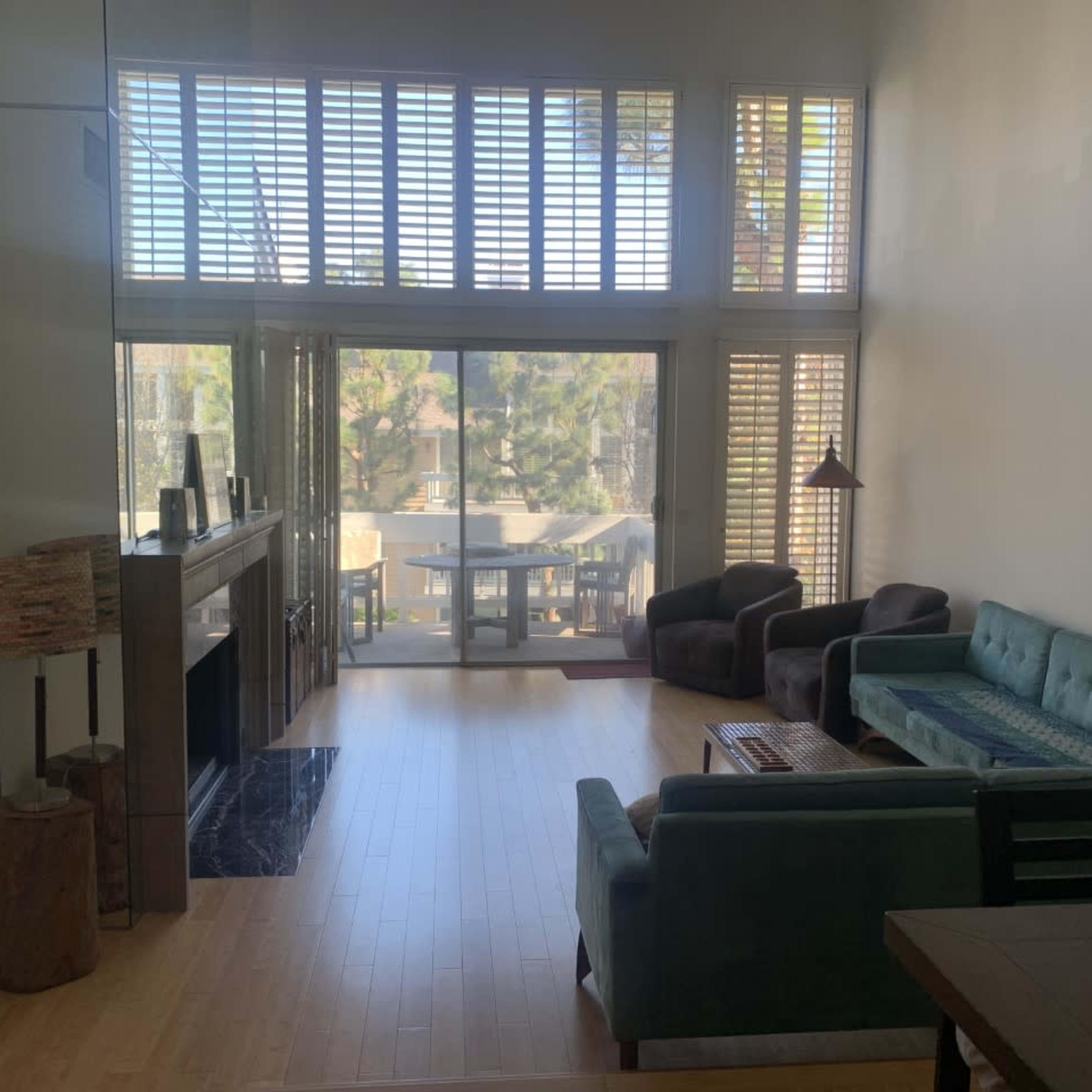 A spacious living room with large windows, a fireplace, and a view of an outdoor area.