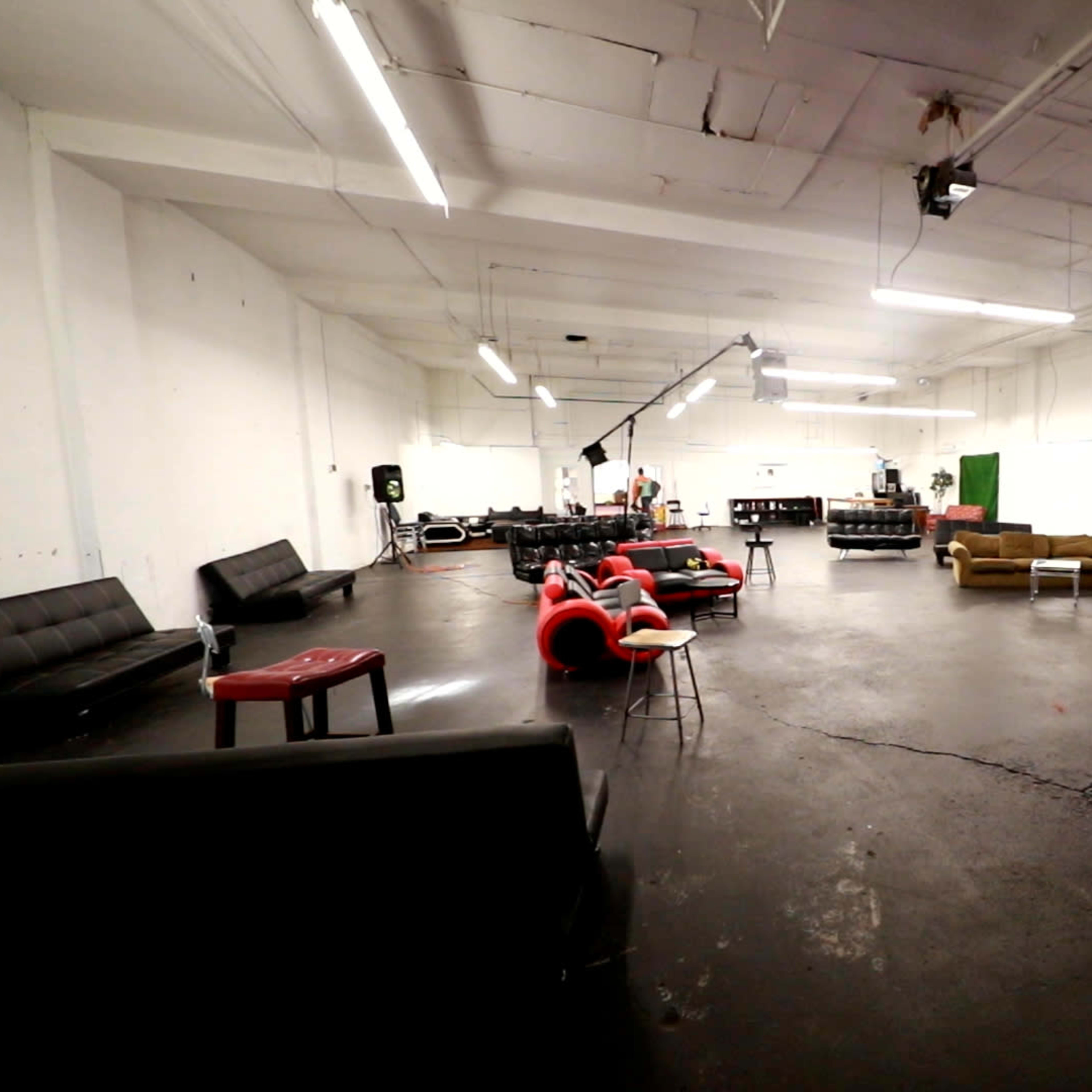 A spacious, empty room with various couches and chairs arranged around the area.