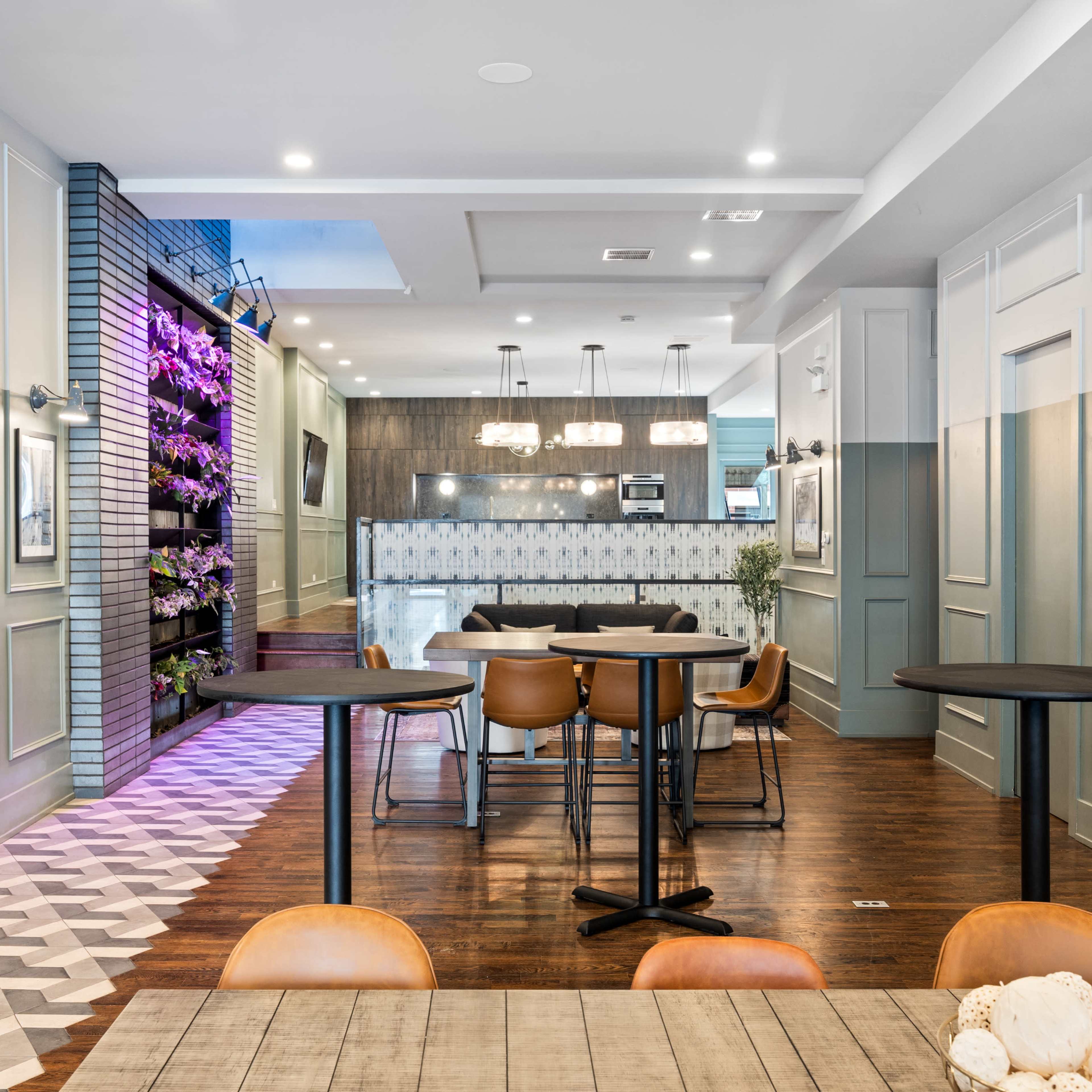 A modern dining area featuring several tables, a stylish bar, and decorative wall elements in a contemporary interior design.